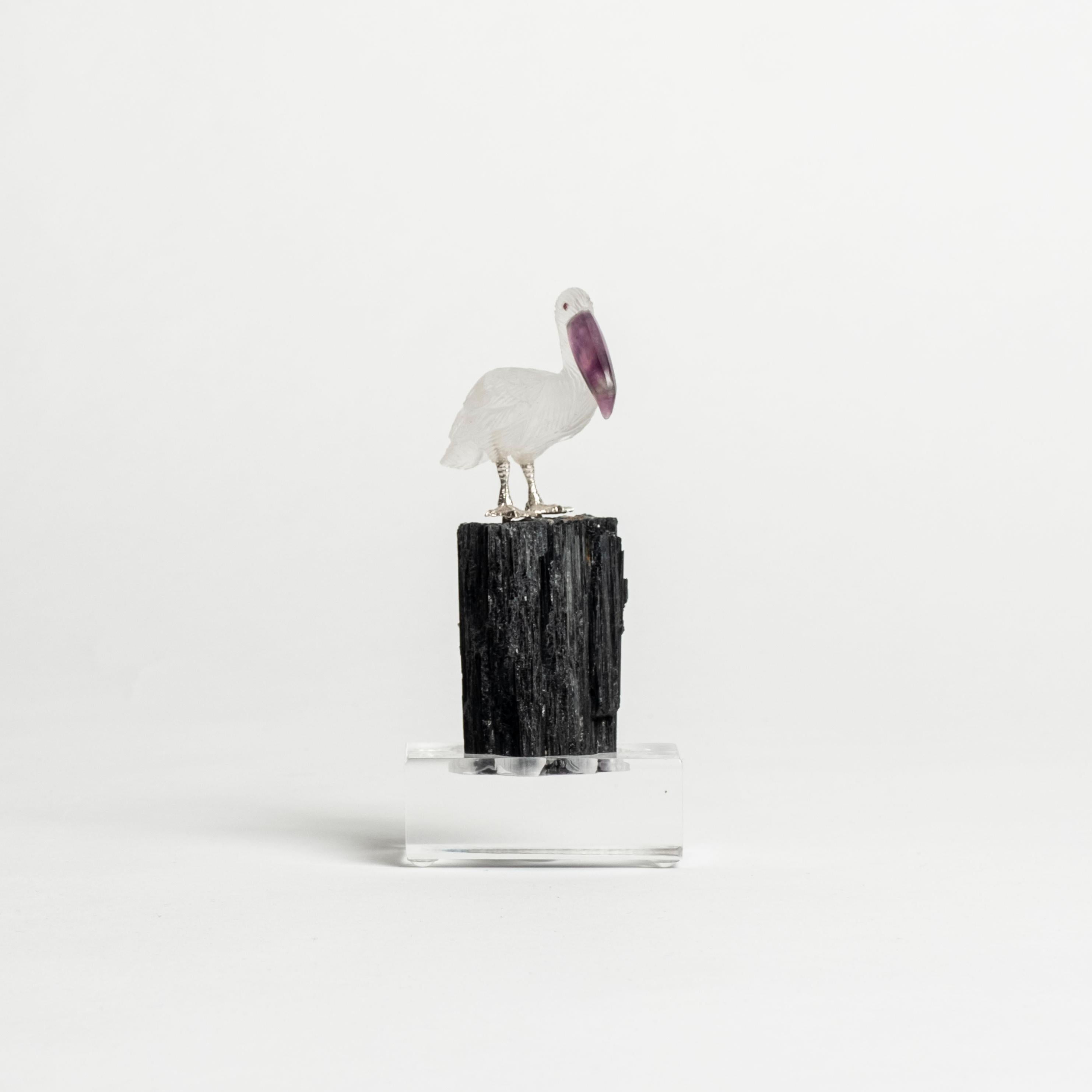 Hand-carved Quartz pelican sculpture set on a black tourmaline natural mineral specimen on lucite base.