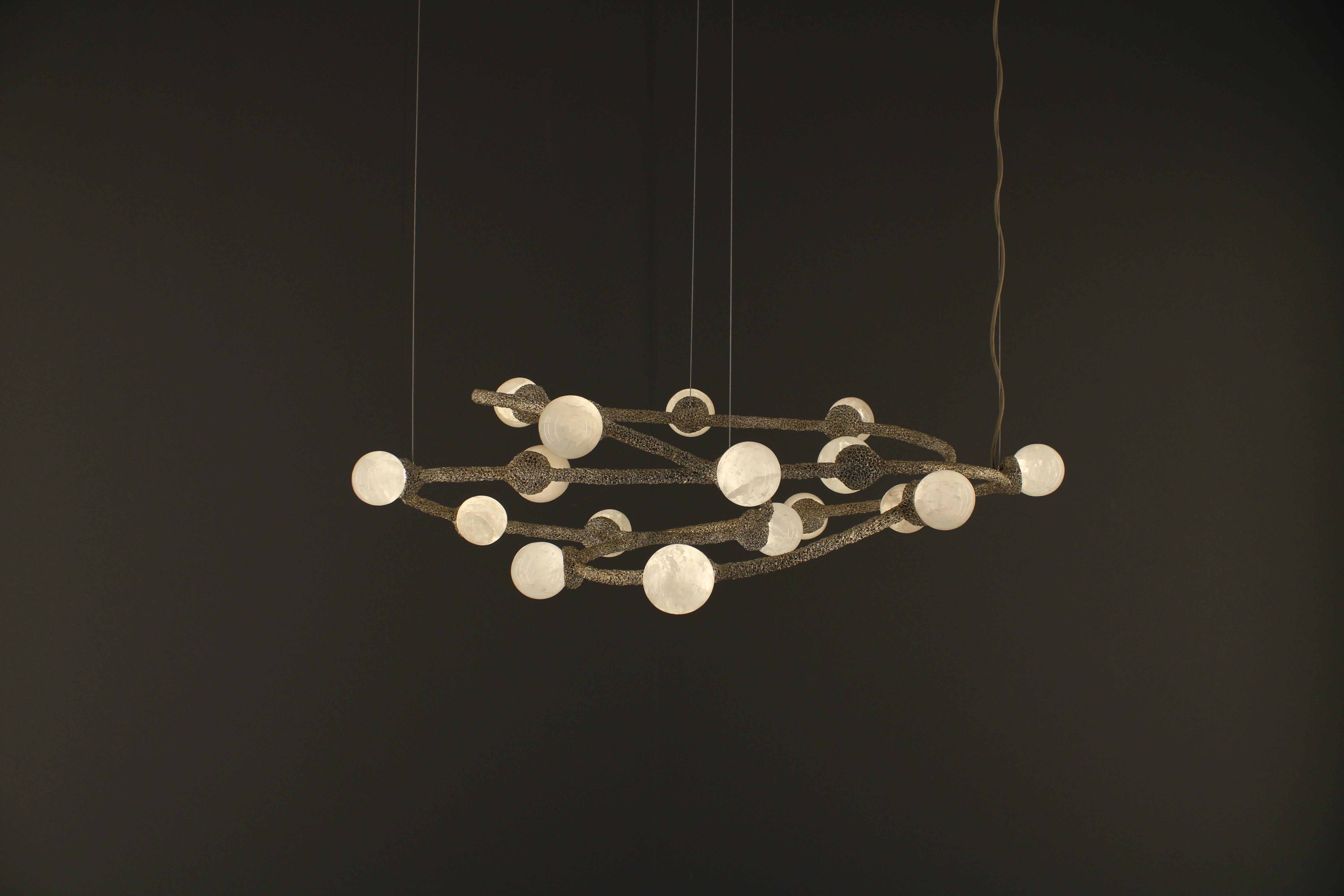 Lampada a sospensione Quartz II di Aver
Dimensioni: D. 59 x L. 100 x H. 30 cm 
Materiali: Quarzo bianco naturale, metallo, ceramica.

Disponibile in placcato oro, placcato argento, placcato oro invecchiato, placcato argento invecchiato, patina oro
