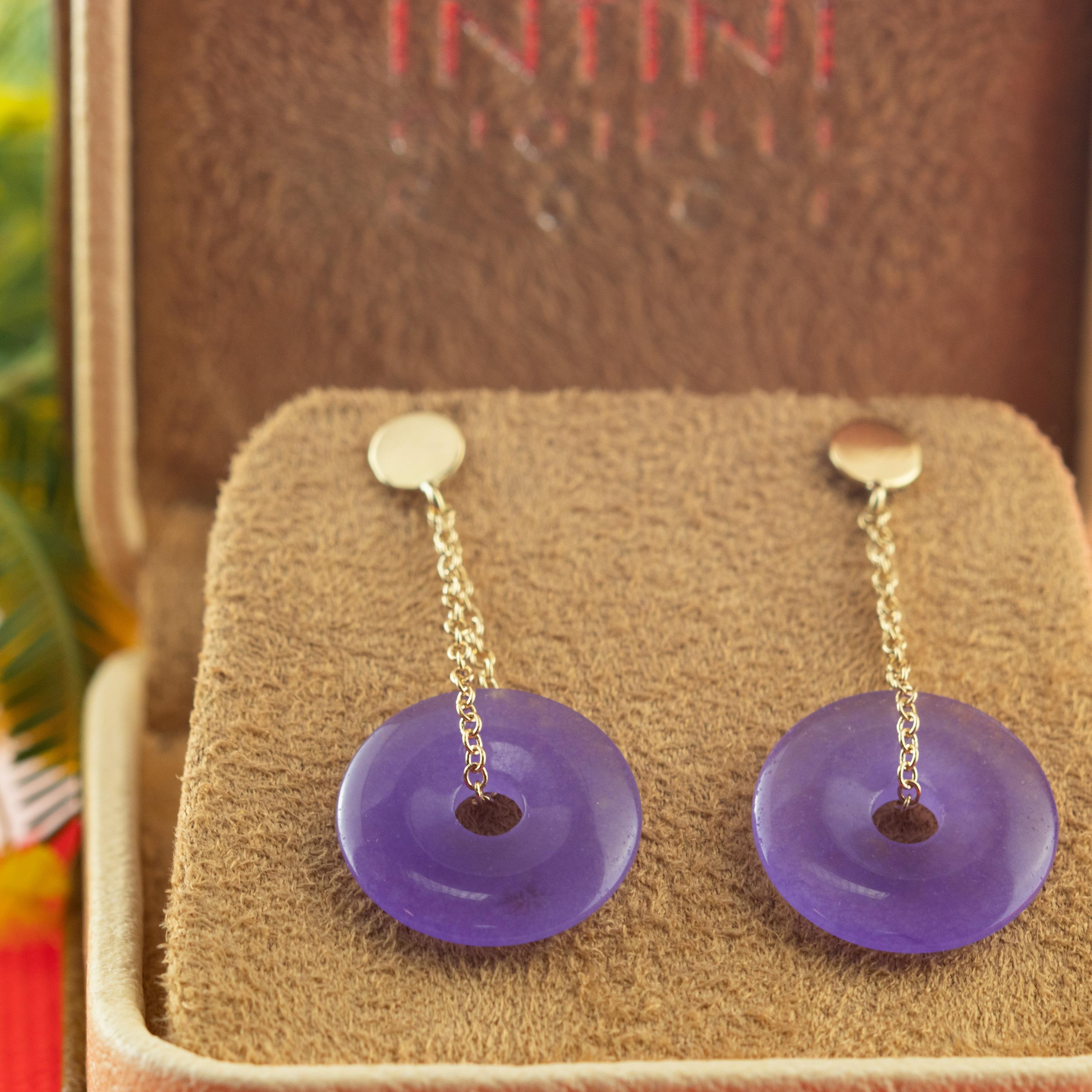 Orecchini a forma di ciambella di quarzo viola incantato, tenuti da catene in oro giallo 18 carati. Disegni moderni pieni di colori vivaci e forme voluminose, che danno vita a pezzi audaci e liberi con un'affascinante eleganza.

Questo design si