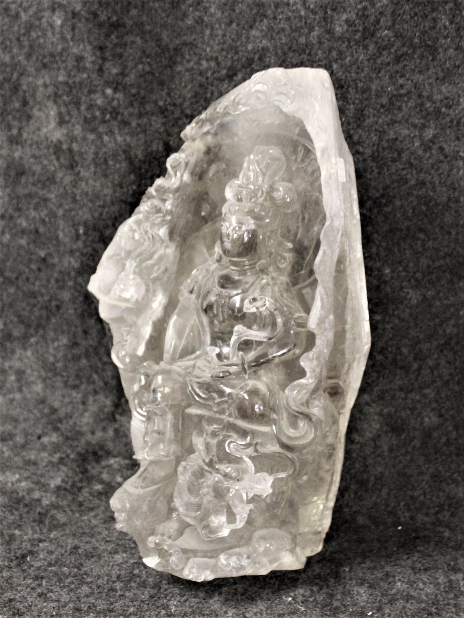 Se trata de una talla muy rara de una Diosa sentada en el interior de un gran Cristal de Roca de Cuarzo .  Difícil ver algún detalle en las fotos .  No se ha encontrado ninguna firma . La piedra mide aproximadamente 15 cm de ancho y 30 cm de alto.