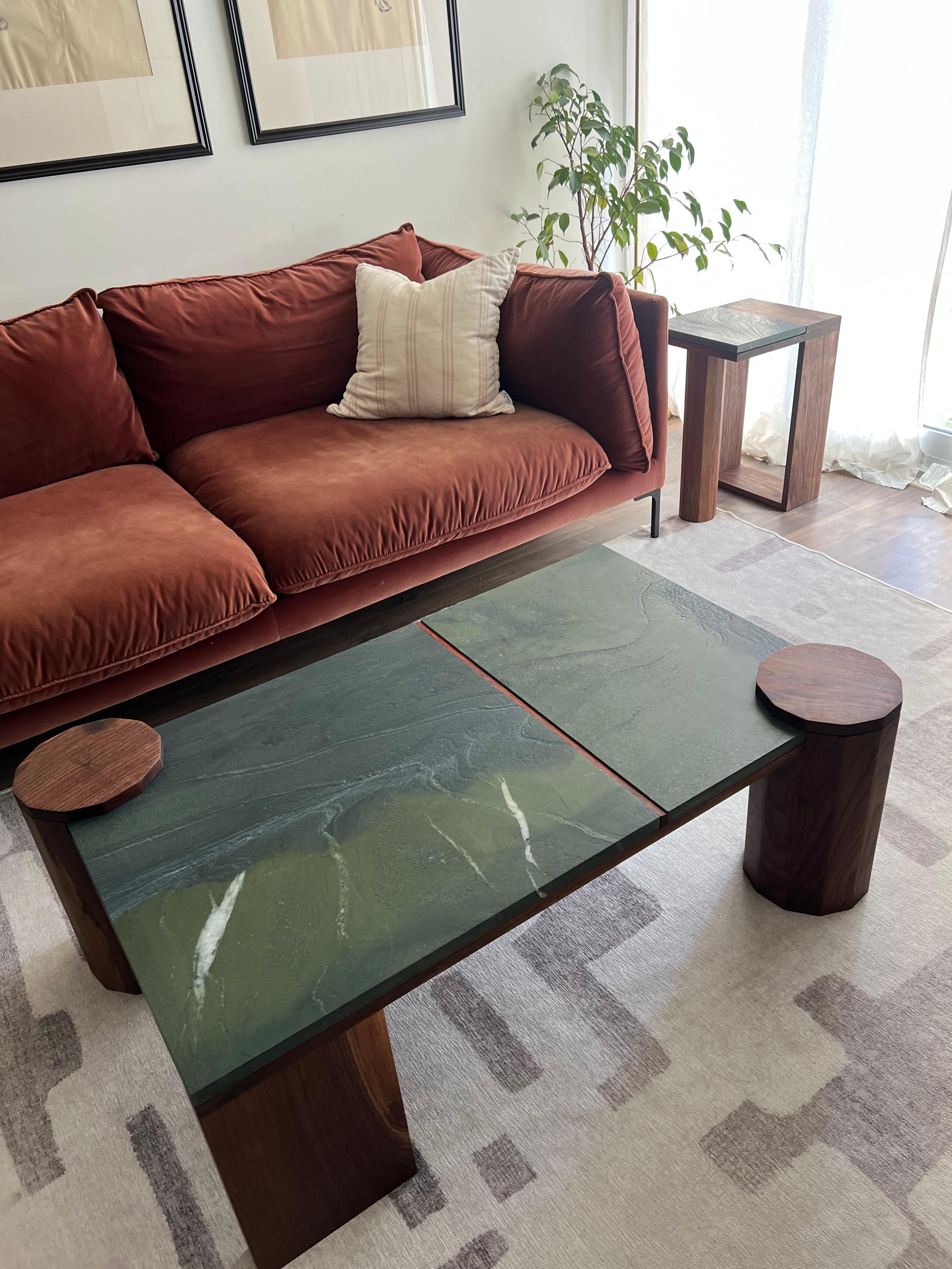 A striking balance of organic materials and architectural form, this handcrafted cocktail table by Redline Design Collective showcases the rich interplay of solid walnut and Avocatus quartzite. The deep, earthy green hues of the stone are streaked