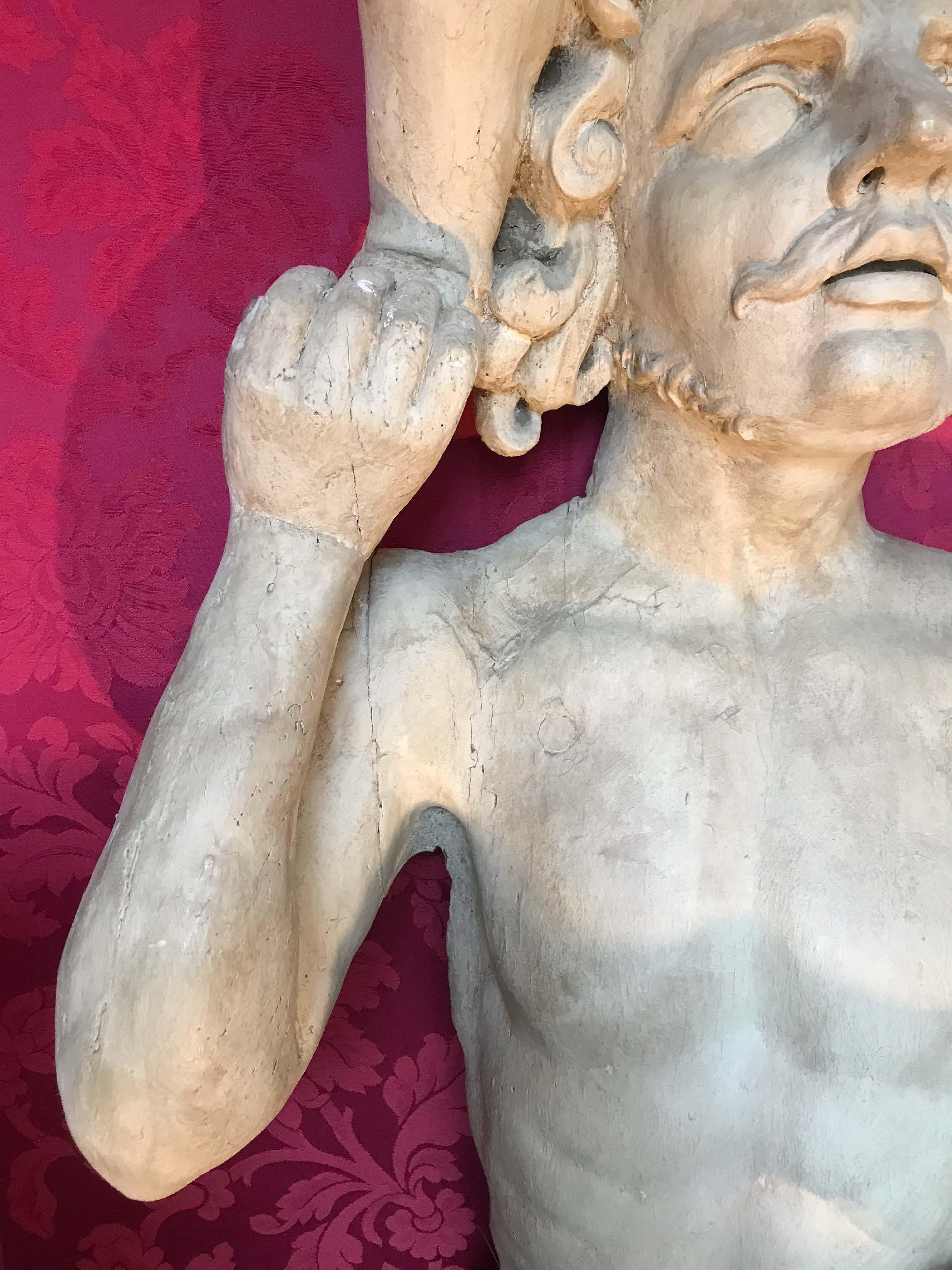 Suite di tre importanti termini scolpiti in bois relaqué grigio che raffigurano uomini drappeggiati alla caviglia, con busti scollati e con le loro teste ricoperte da putti. In due coppie, due termini rappresentano il reggiseno destro con il piede