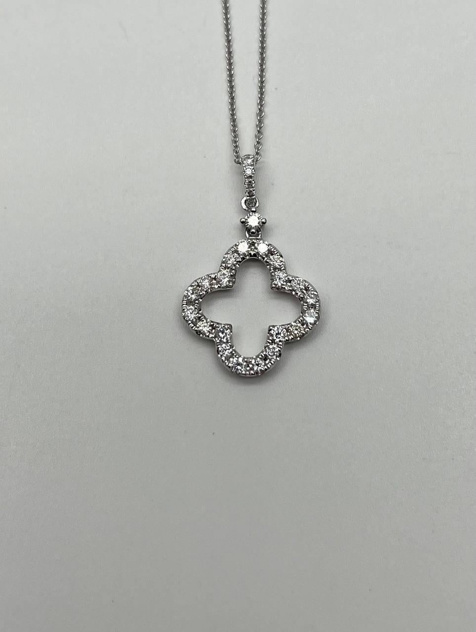 Questa collana con ciondolo è realizzata in oro bianco 18 carati. Il ciondolo presenta un design a quatrefoil ornato da diamanti bianchi, per un totale di circa 0,75 carati. La catena è delicata e completa l'intricato design del ciondolo.
