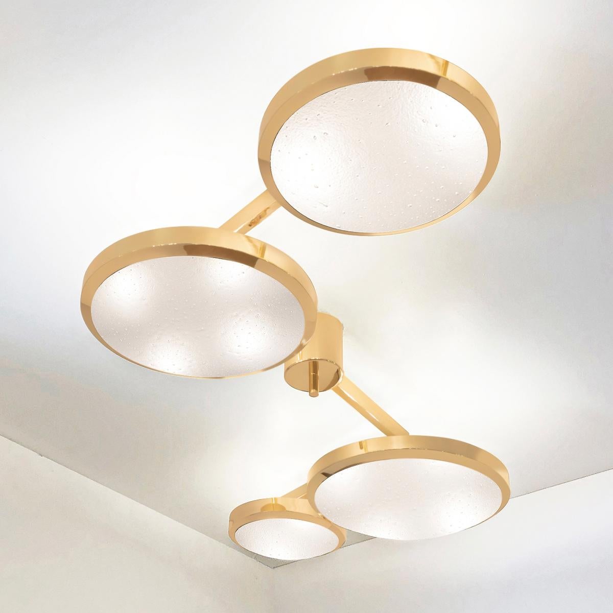 The Quattro ceiling light plays with the notion of lines and shapes, bringing the concept to life with its distinctive winding frame with four variable size shades at staggered heights. The first images show the fixture in our polished brass