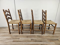 Four solid wood dining chairs with woven straw seat