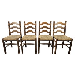 Four solid wood dining chairs with woven straw seat
