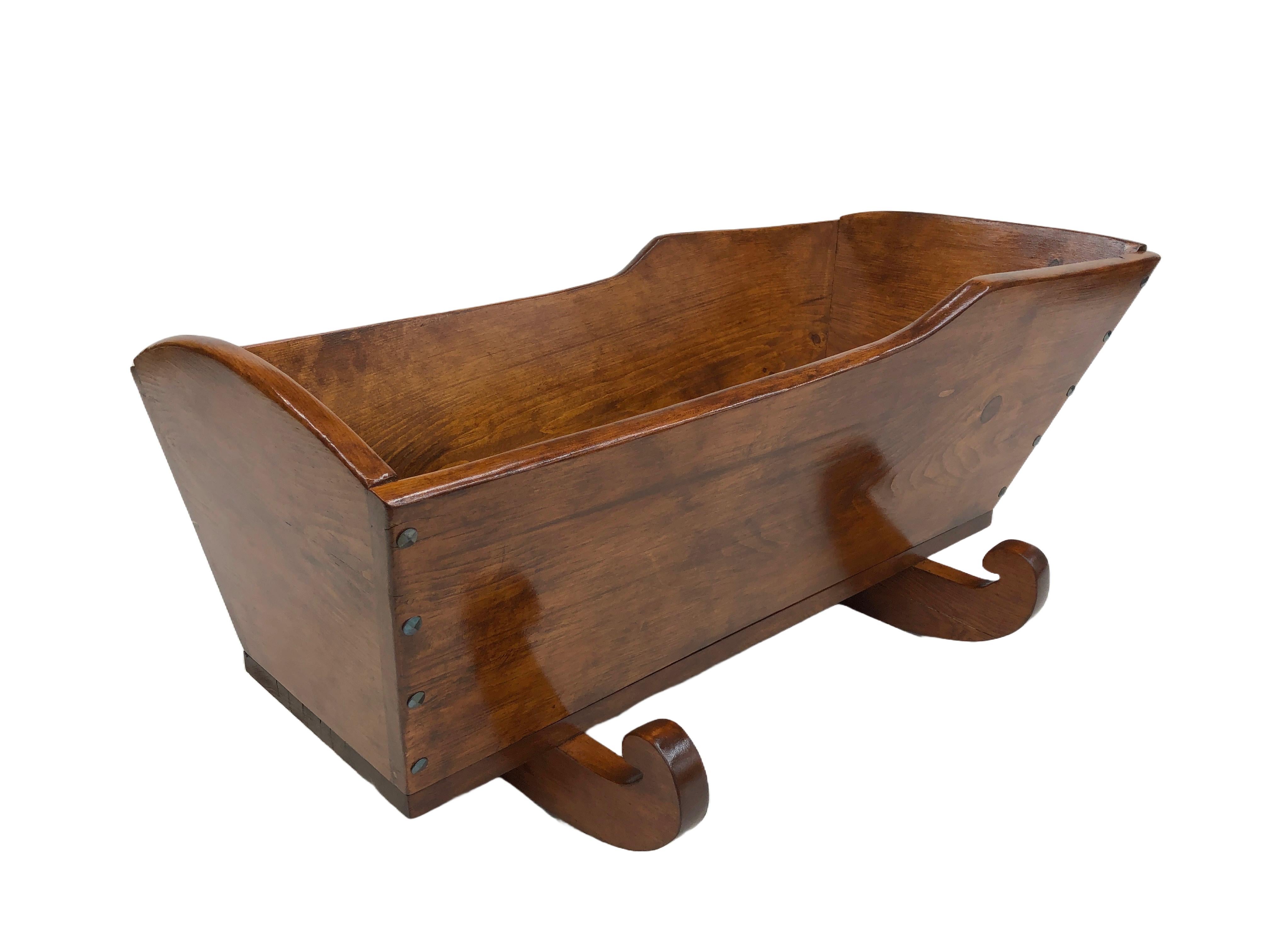 Antique nineteenth-century Quebec Pine cradle. Professionally restored. Hand-cut blued steel French diamond-head nails that are functional and decorative. Joints have been reglued and bisquited. Striped and sanded to bare wood and restained. Three