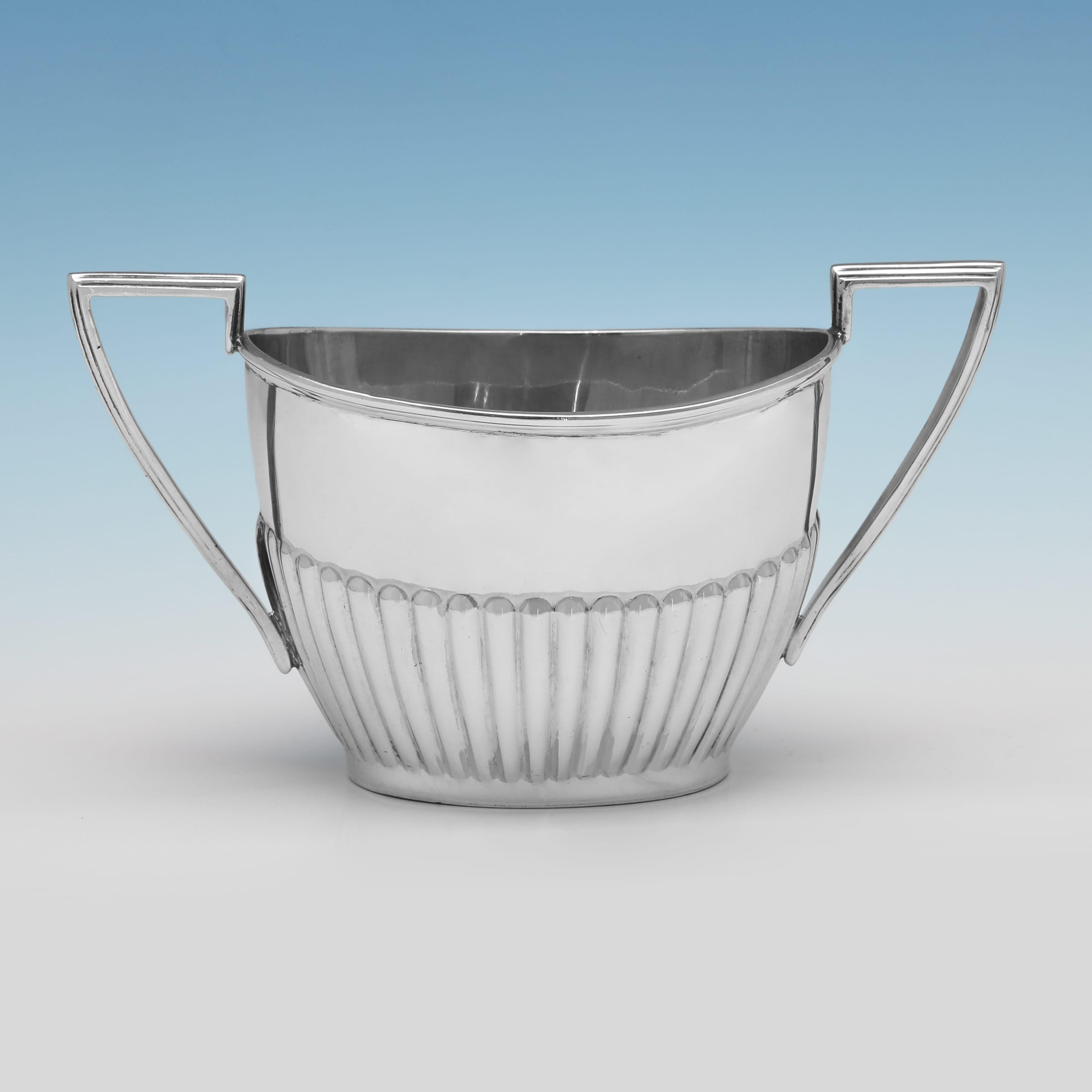 Hallmarked in Sheffield in 1907 by Walker & Hall, this handsome Antique, Edwardian, period, Sterling Silver Sugar & Cream Set, is in the 'Queen Anne' style, with half fluted decoration and reed borders. The set together weighs 7.40 troy ounces.
