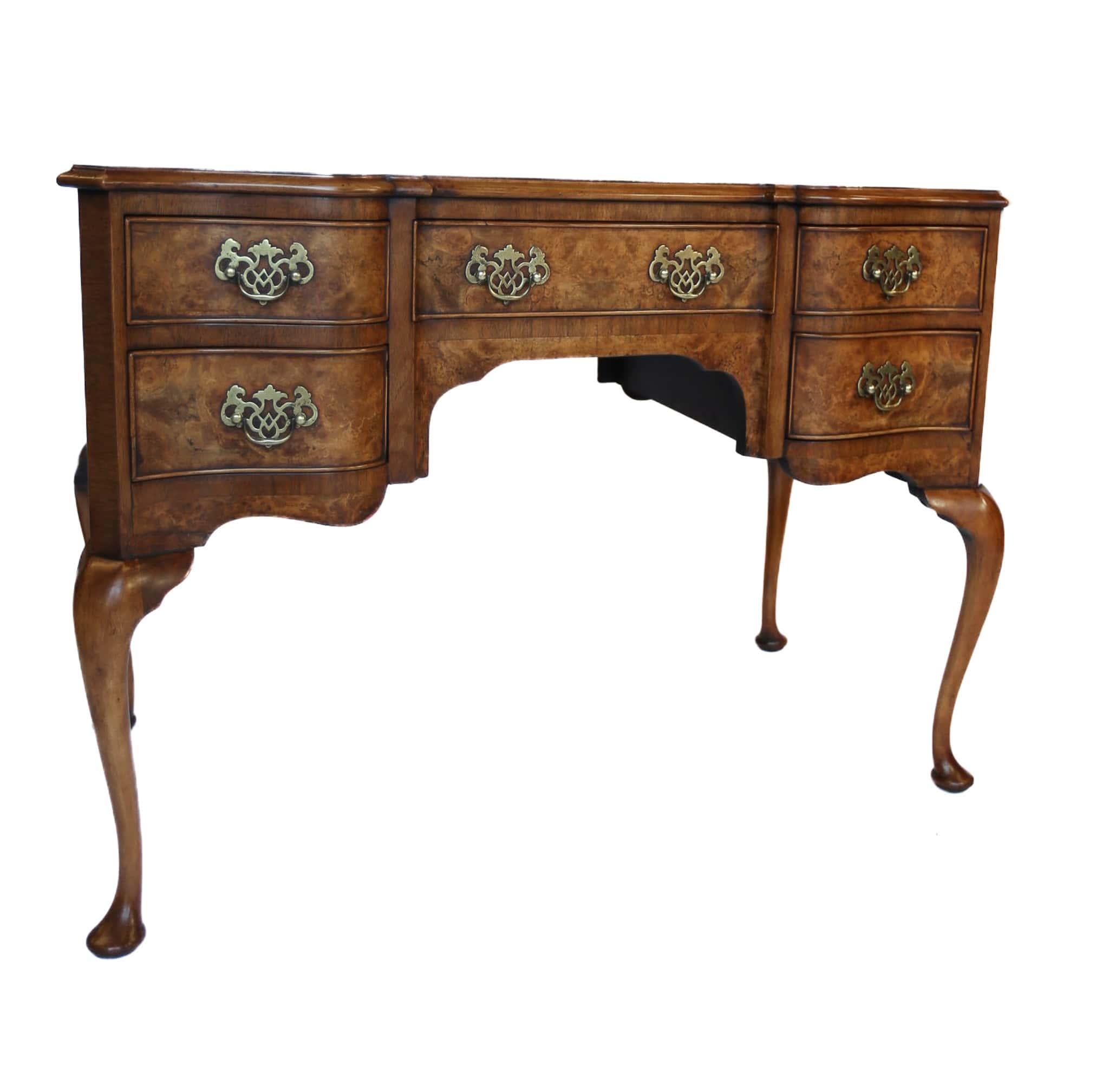 Tavolino da toilette in radica di Queen Anne del 1930 circa
Impiallacciatura in radica di noce sul piano con bordatura incrociata in noce
Fronte sagomato con 5 cassetti, 
Maniglie in ottone forate,
Siede su gambe a forma di cabriole e piedi a