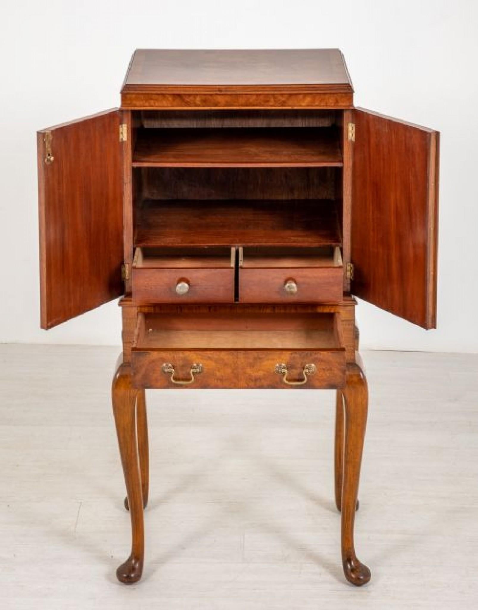 Walnut Queen Anne style cabinet on stand.
This quality cabinet is raised upon typical queen anne style legs with pad feet.
circa 1920
The base having 1 mahogany lined drawer and a shaped frieze,
the top of the cabinet featuring 2 doors with