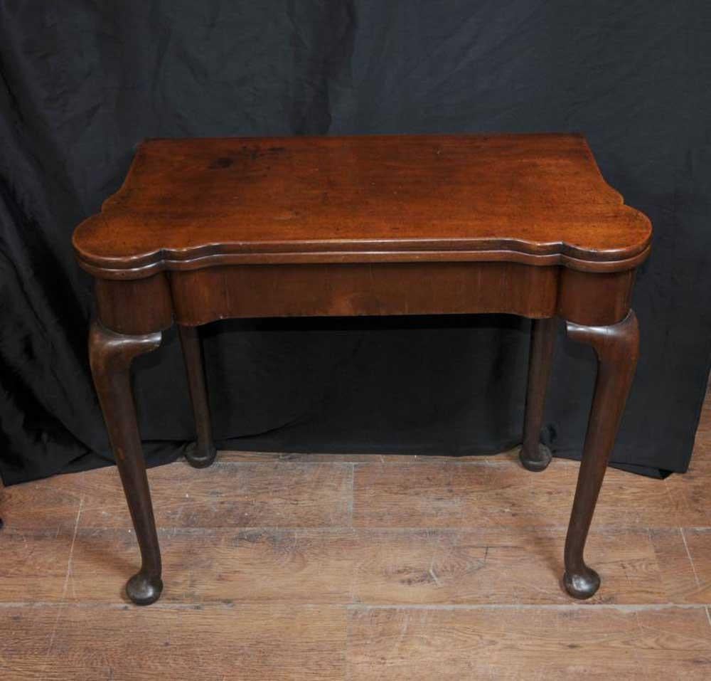 - Stunning Queen Anne card table in mahogany
- Classic pad foot feet and curved Queen Anne legs
- Table opens out to reveal blue beize material games playing surface
- Bought from a dealer in London\'s Notting Hill Gate
- Offered in great shape