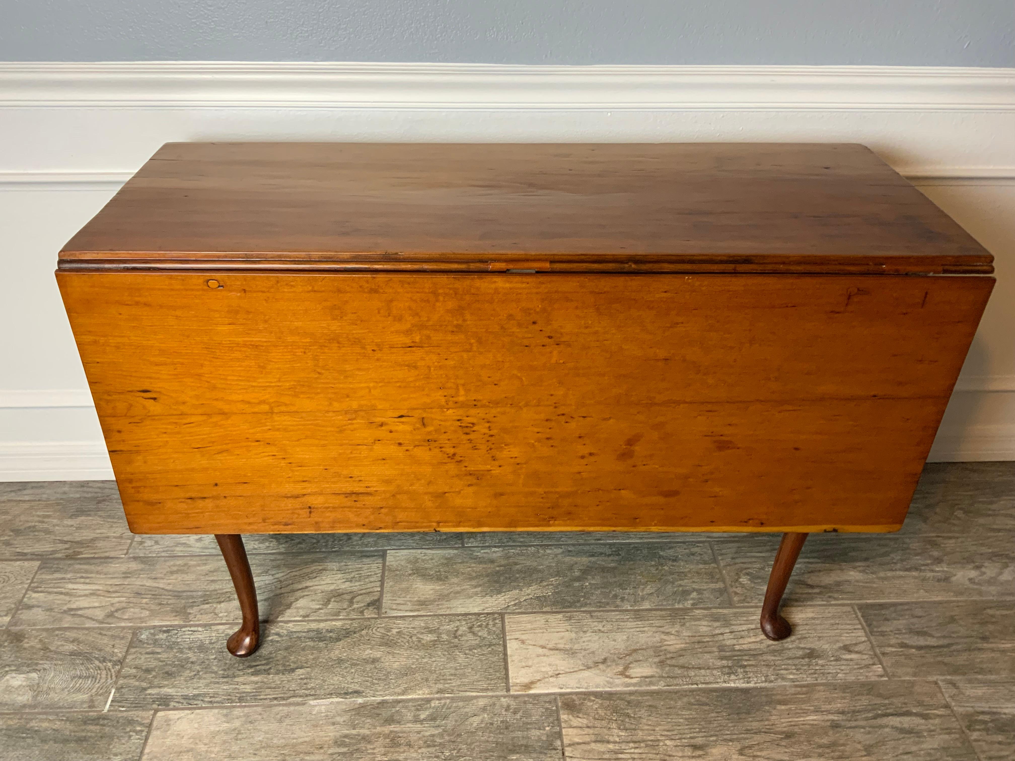 New England Cherry Queen Anne swing leg drop leaf table. Excellent color and patina to the old Cherry tops. Dovetailed case with slender cabriole legs ending in pad feet. Old refinish in very good condition. Looks to be an early marriage of tops and