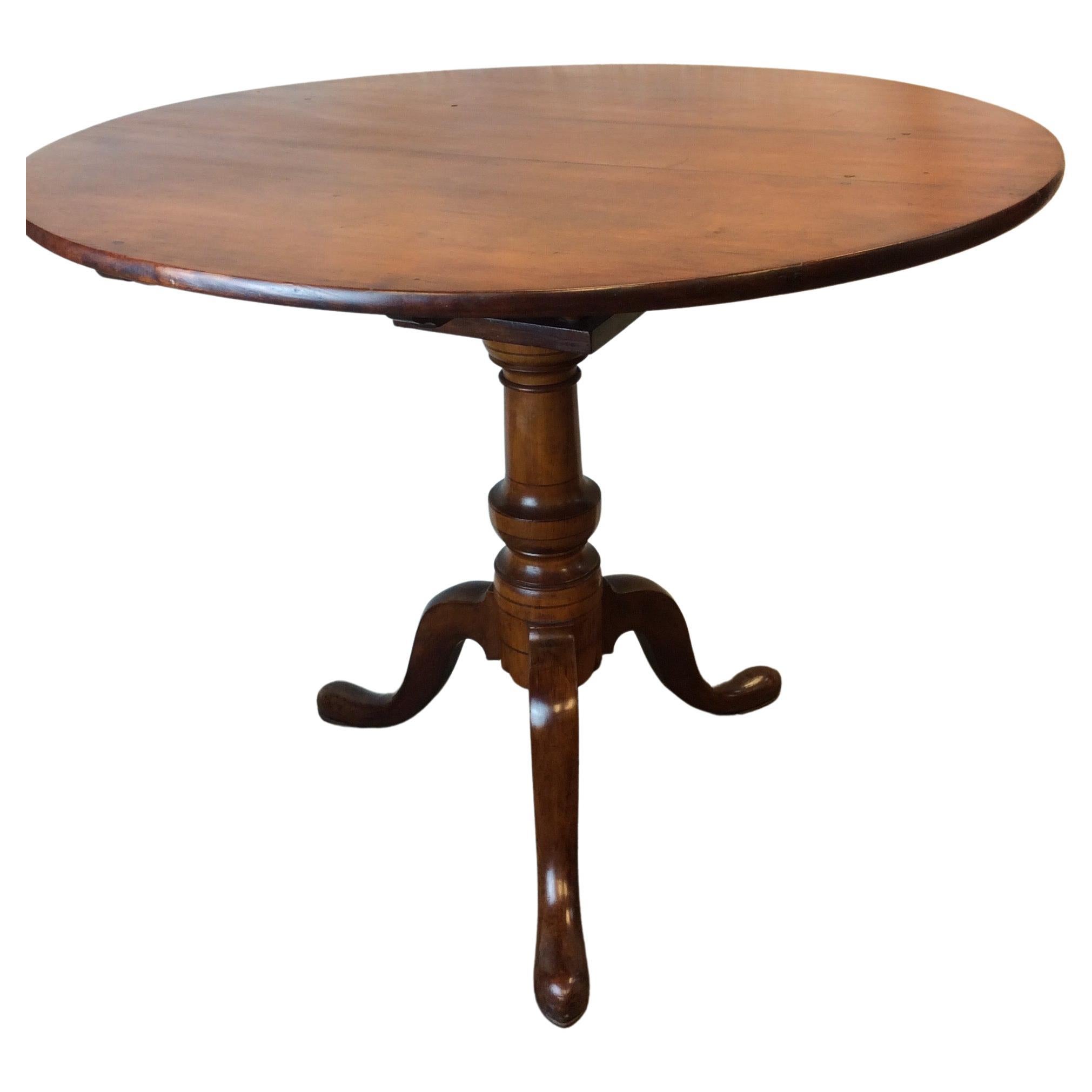 An excellent Queen Anne Cherry bird cage tilt top tripod table probably Connecticut 1780-1800. This table is in excellent condition and retains a very old refinish and great color and patina to the Cherry. The top is 1/2” out of round in the