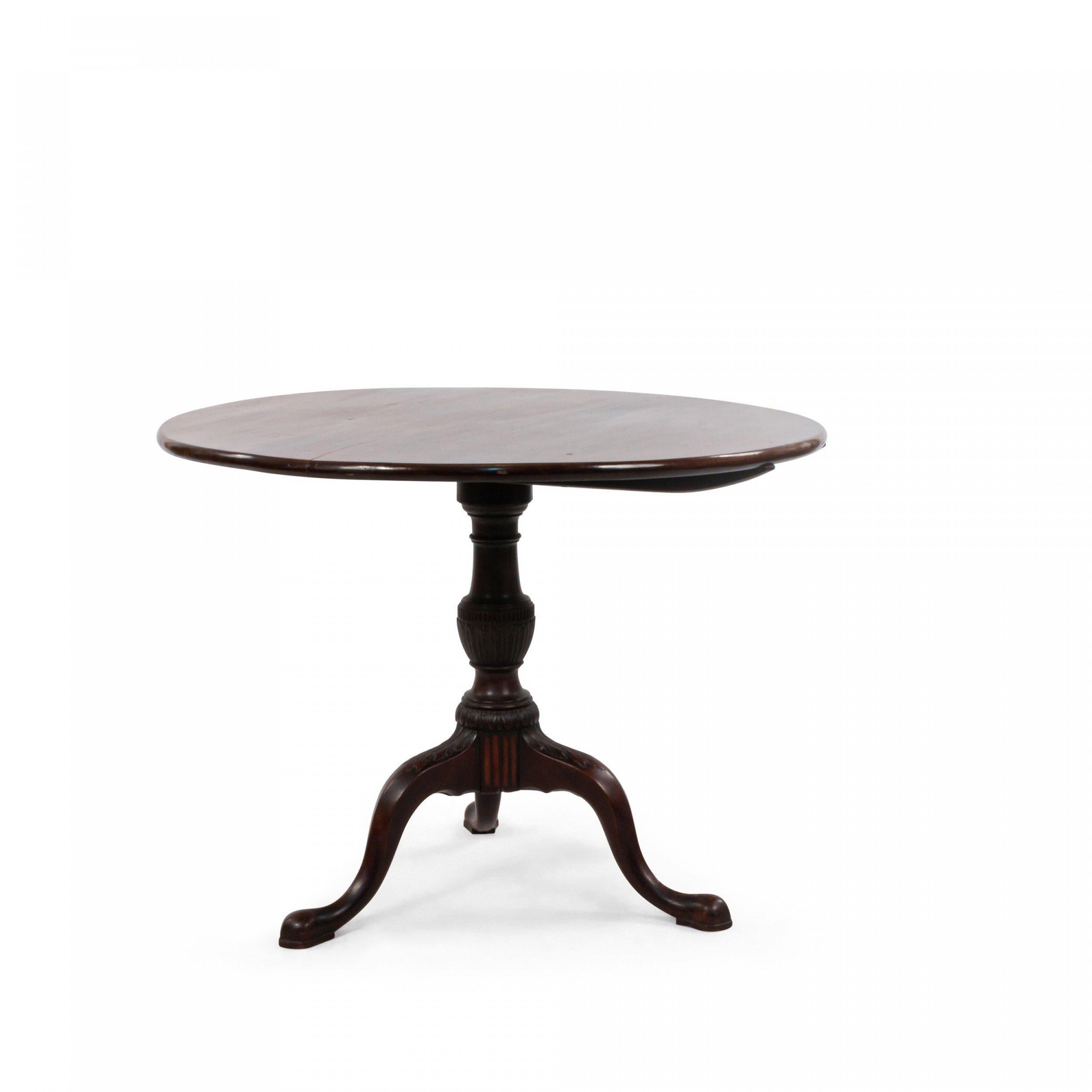 Queen Anne, possibly American, (18th Century) mahogany round tilt top table supported on a pedestal with three carved cabriole legs with pad feet.
  