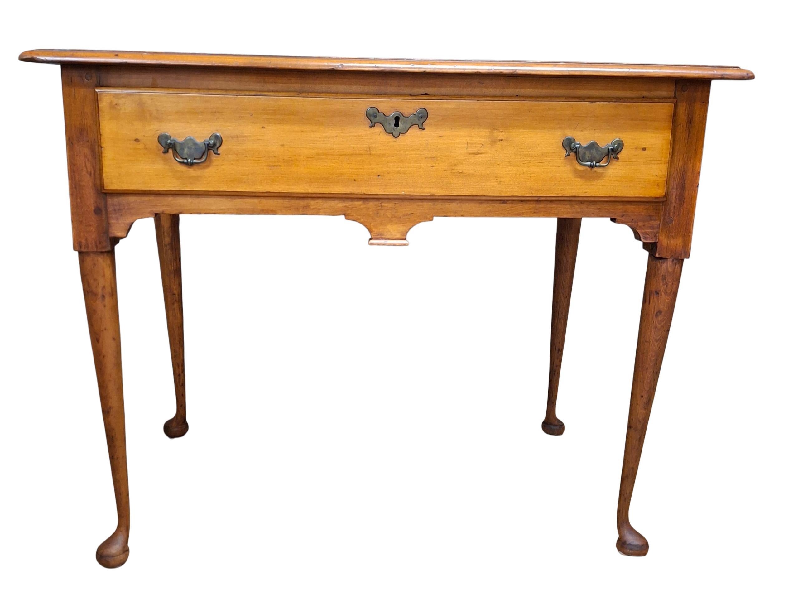 Charmante table de travail/de bureau en cerisier Queen Anne du 18e siècle avec un seul tiroir, des pieds effilés et des pieds pad.

35