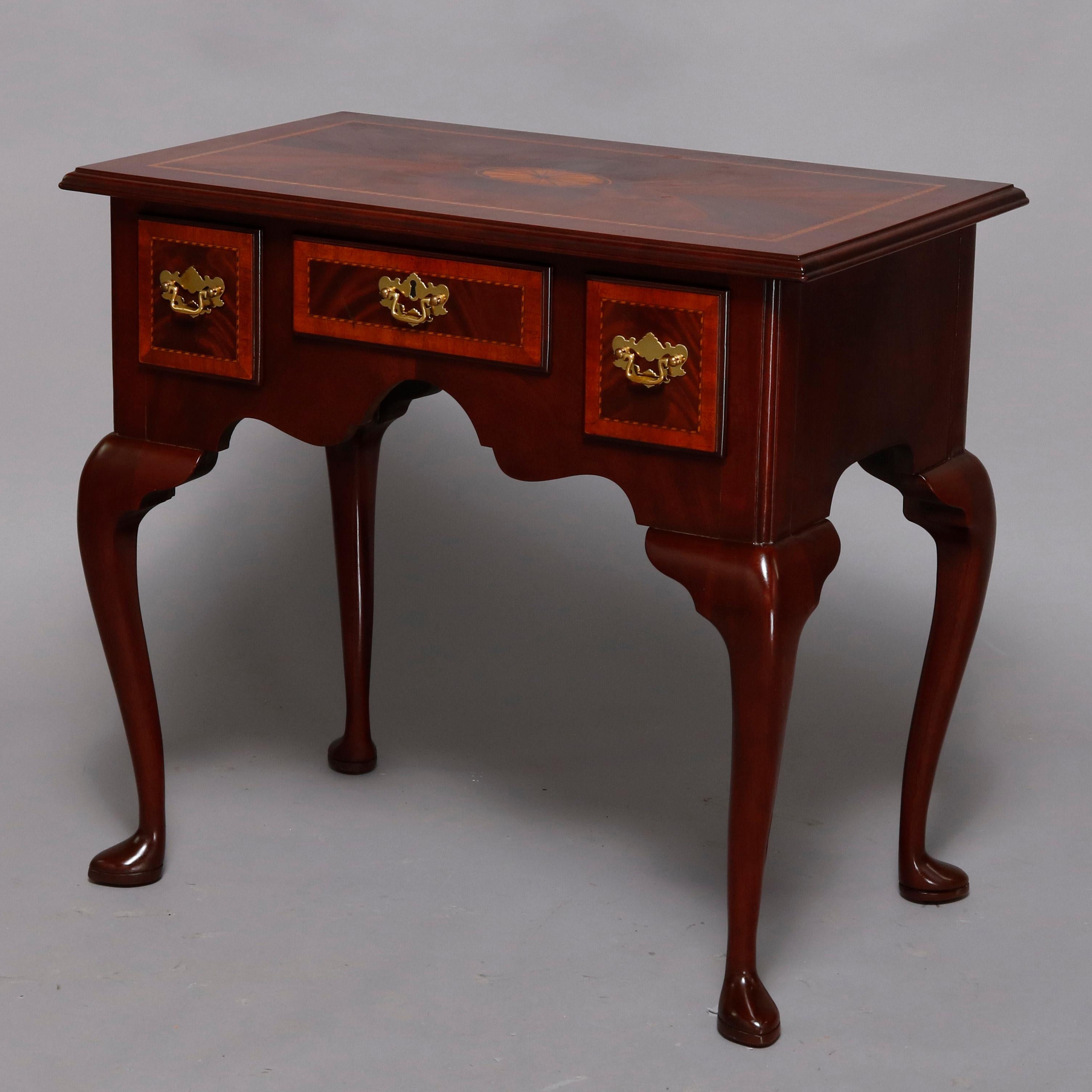 A Queen Anne style server custom handcrafted by Councill Craftsmen offers flame mahogany construction with cabinet having three cross banded drawers surmounted by satinwood inlaid top with central patera and rope twist banding, raised on cabriole