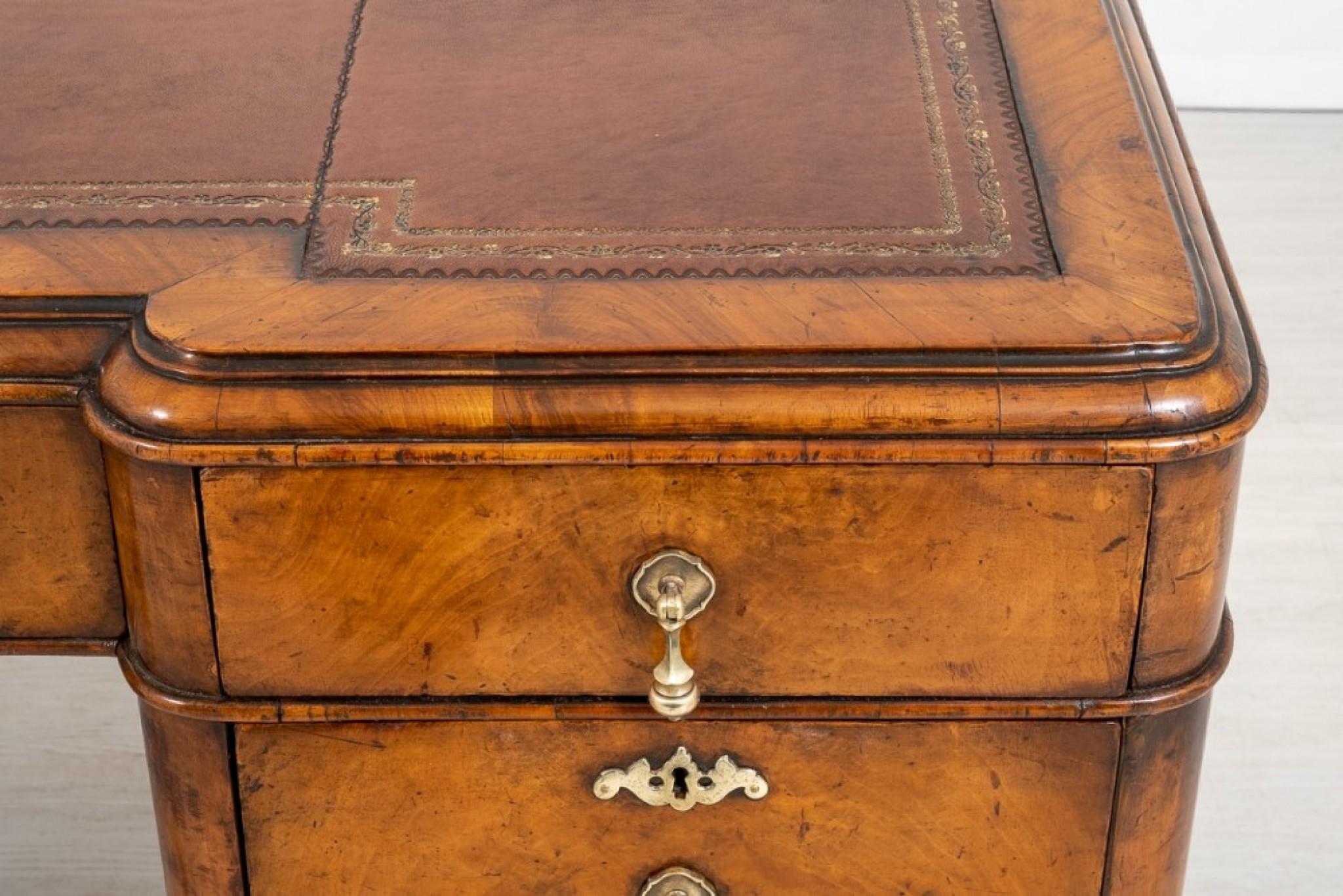 Stunning walnut Queen Anne style desk.
circa 1920
This Wonderful desk is Raised Upon Cabriole Legs with Boldly Carved Ball and Claw Feet and Carved Knees.
The Desk features an arrangement of 7 oak lined drawers which retain their original Brass