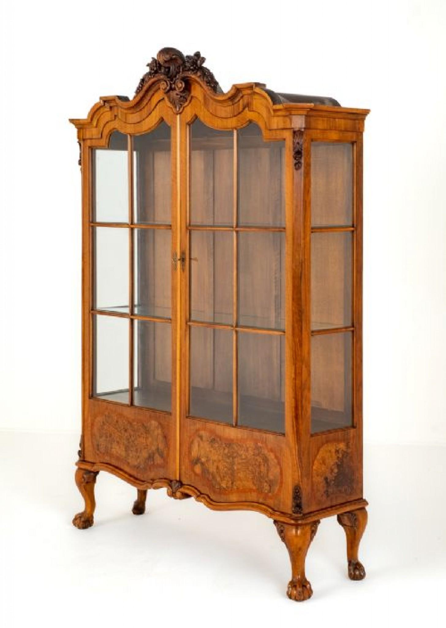 Good quality Queen Anne style walnut display cabinet.
This cabinet stands upon short cabriole legs with well carved ball and claw feet.
1880
The piece features 2 glazed doors, each door having shaped burr walnut panels with satinwood cross