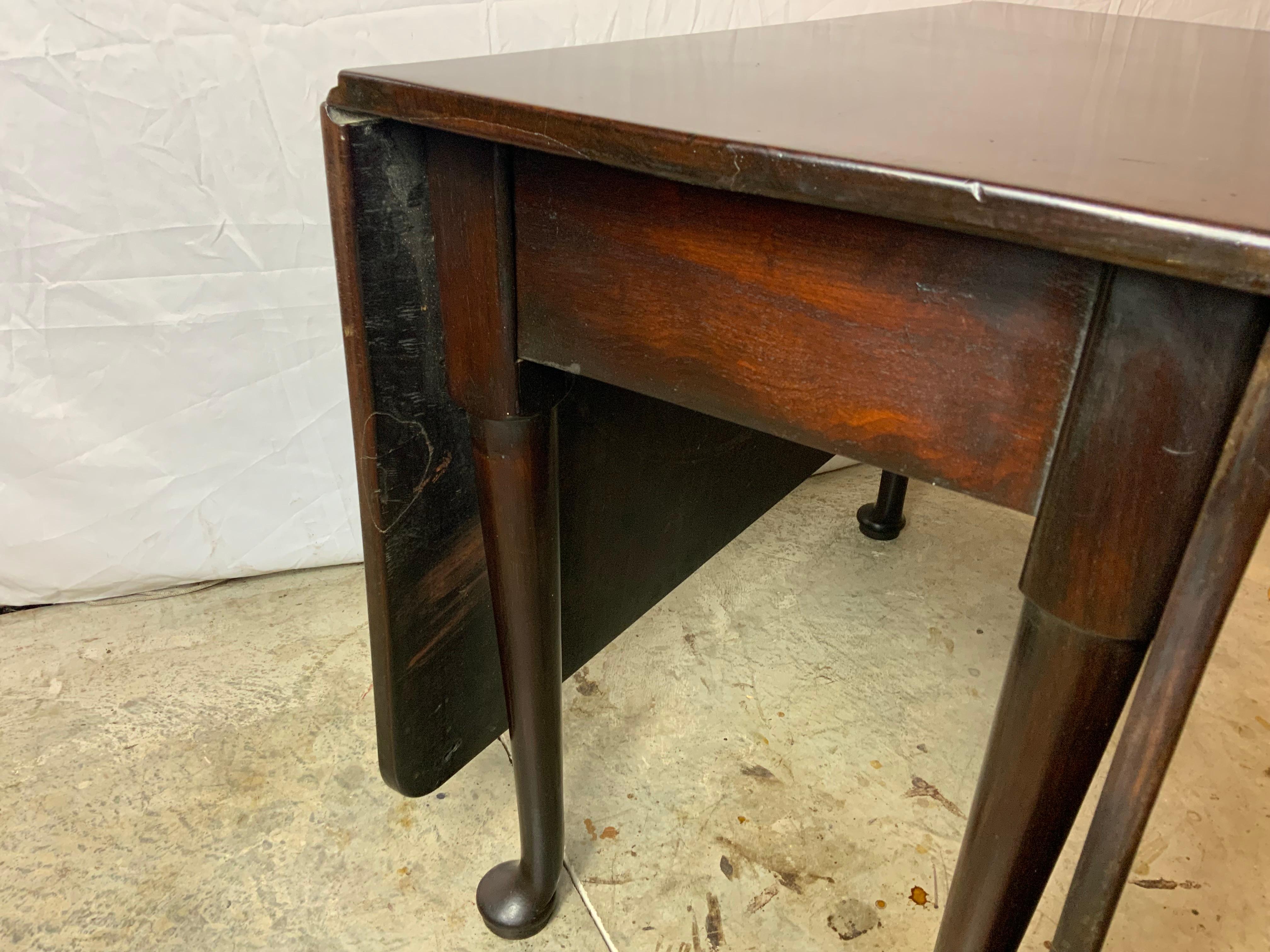A very nice solid heavy 18th century Queen Anne drop leaf table.  Nicely tapered swing leg ending in a nice wide pad foot.  Solid Cuban Mahogany tops in very good flat condition. Original surface lightly cleaned and waxed exhibits a very nice color
