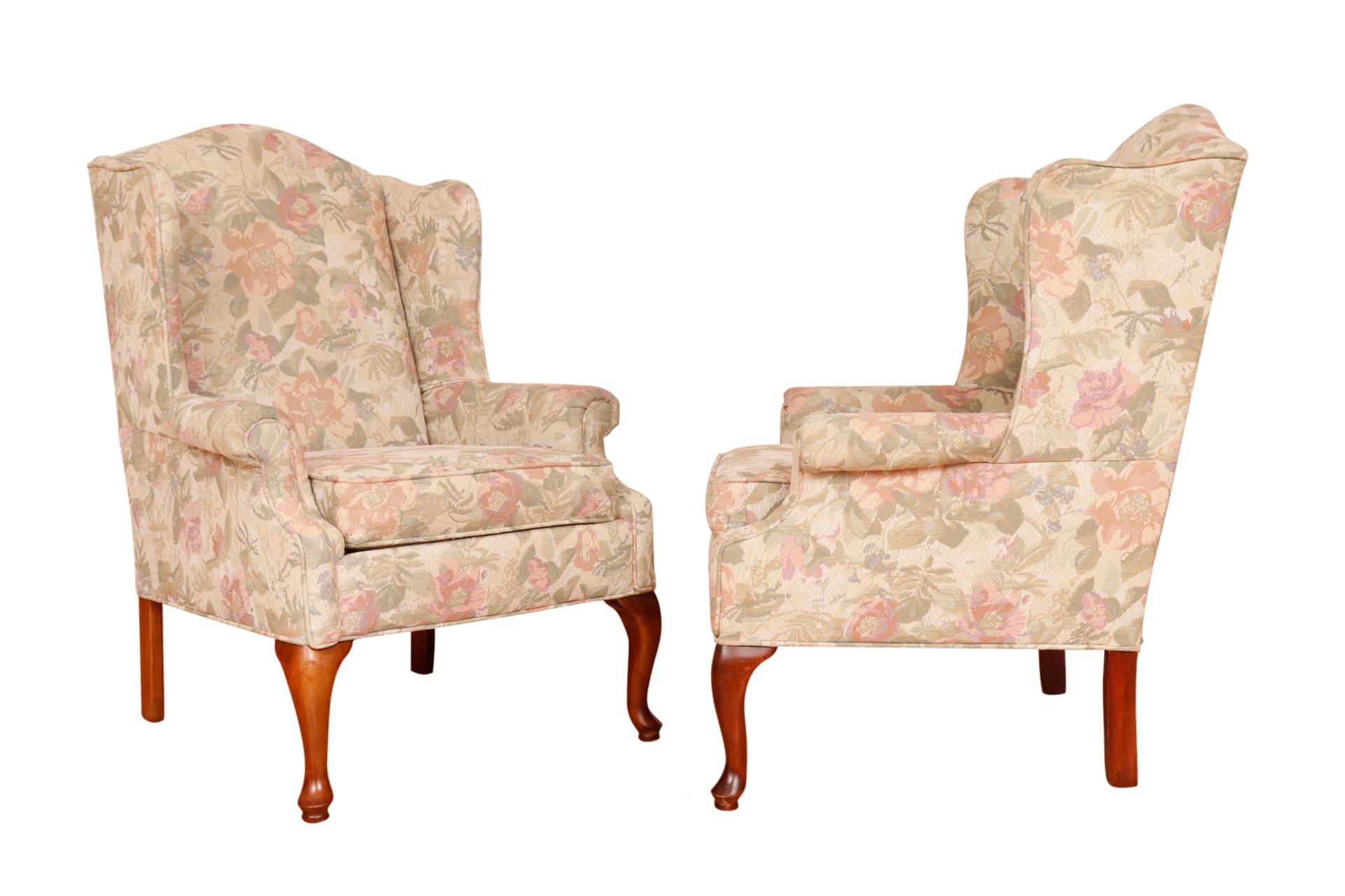 A pair of Queen Anne style wingback chairs made by Rowe Furniture. Upholstered throughout in a floral jacquard decorated with roses in blush and rich foliage in sage over a taupe base. Cabriole legs finish in round pad feet. Arm height 24