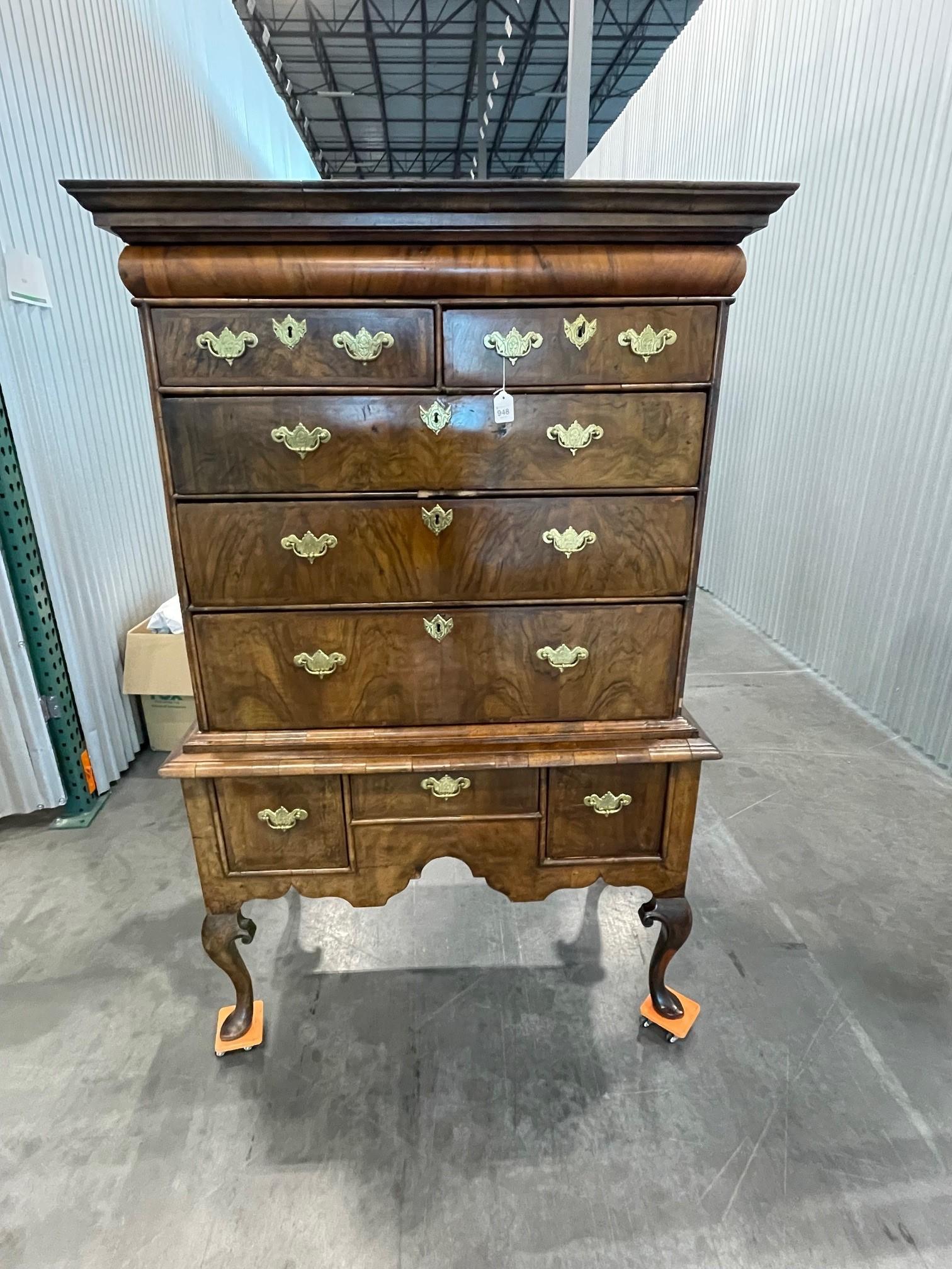 An early eighteenth century herringbone-banded figured walnut chest on stand  with concave molded drawer to the cornice above two small and three long graduated drawers, the base fitted three small drawers above a shaped apron; standing on shaped