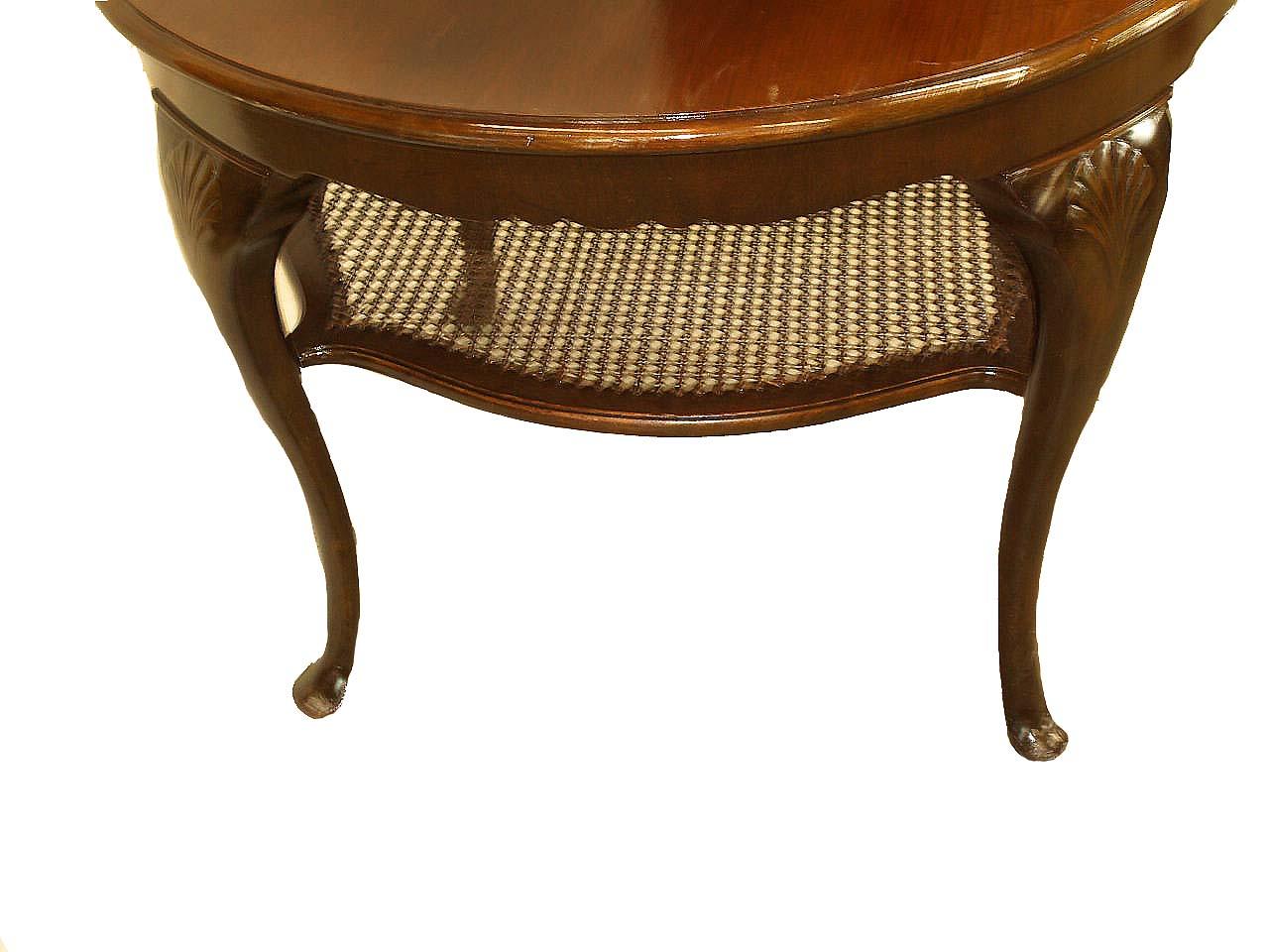 Queen Anne mahogany center table, with nicely figured round top, serpentine shaped cane shelf below. The cabriole legs have a carved shell on the knee terminating with a pad foot.