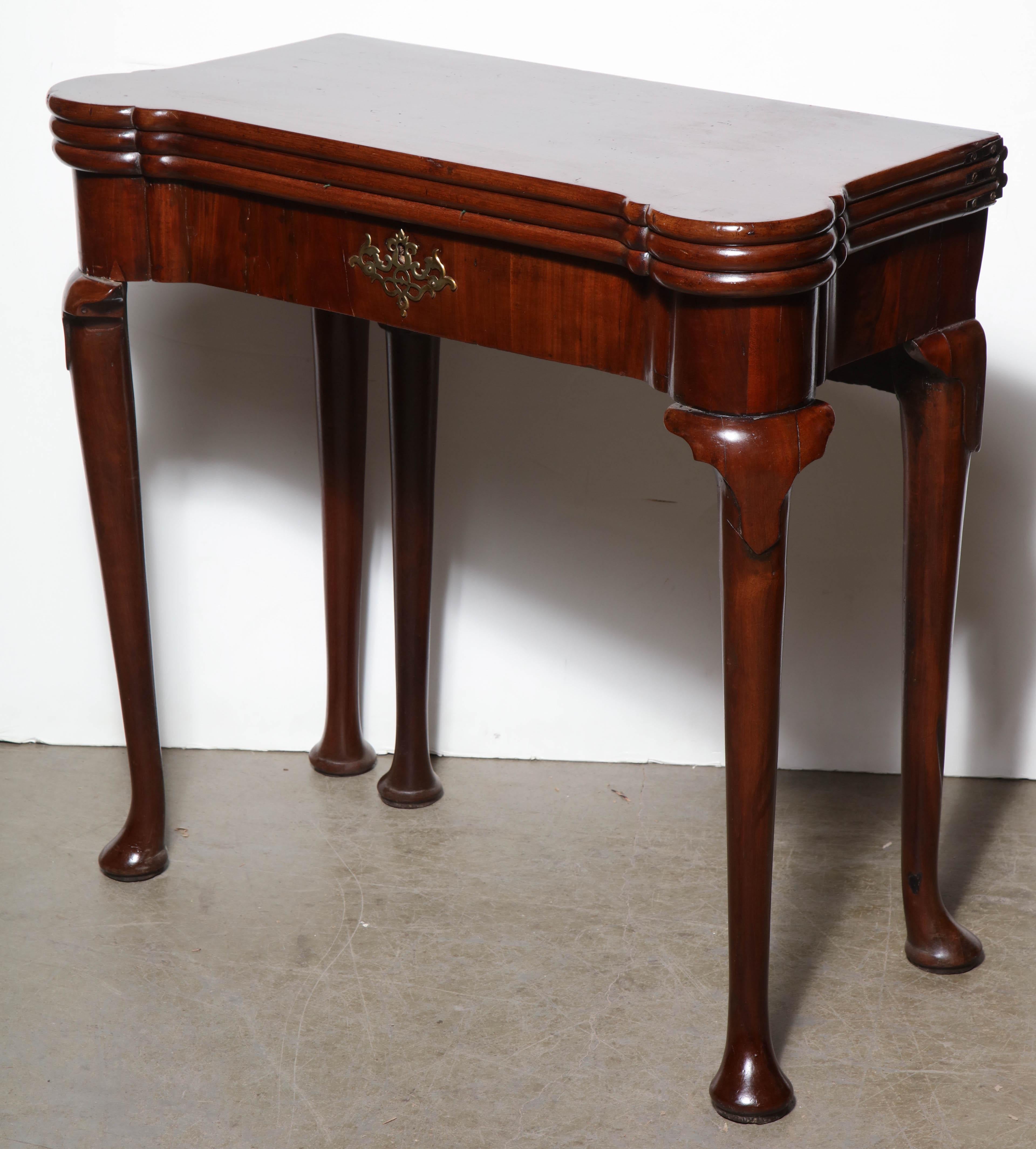 A rare English Queen Anne mahogany triple top card table with turret corners, pocket fitted interior and a storage well.