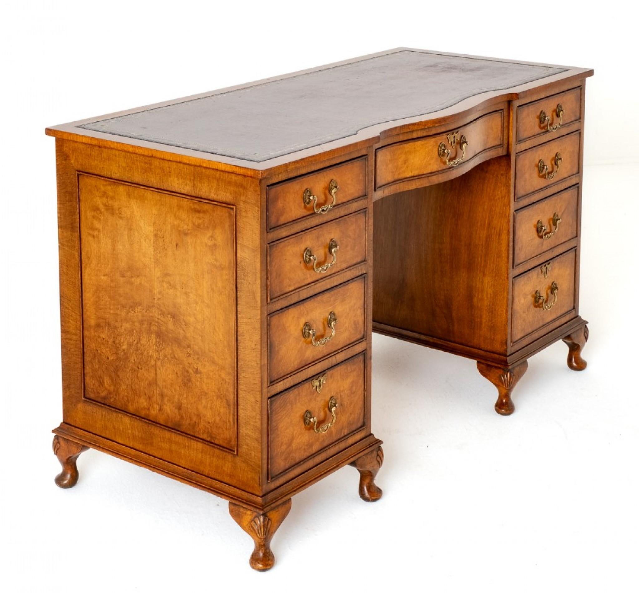 Queen Anne Style Walnut Pedestal Desk.
This Desk is Raised upon Squat Cabriole Legs with Carved Knees.
Having an Arrangement of 9 Mahogany Lined Drawers, the Centre Drawer Being of a Shaped Form.
The Drawers Retain their Decorative Brass Swan Neck