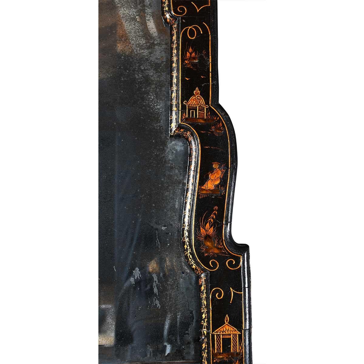 Ein Spiegel aus der Queen-Anne-Zeit mit fein verziertem schwarz-goldenem Chinoiserie-Rahmen. Bestehend aus zwei abgeschrägten Spiegelplatten. Die obere, kleinere Platte hat eine gewölbte Form. Die untere Spiegelplatte kann ersetzt werden.