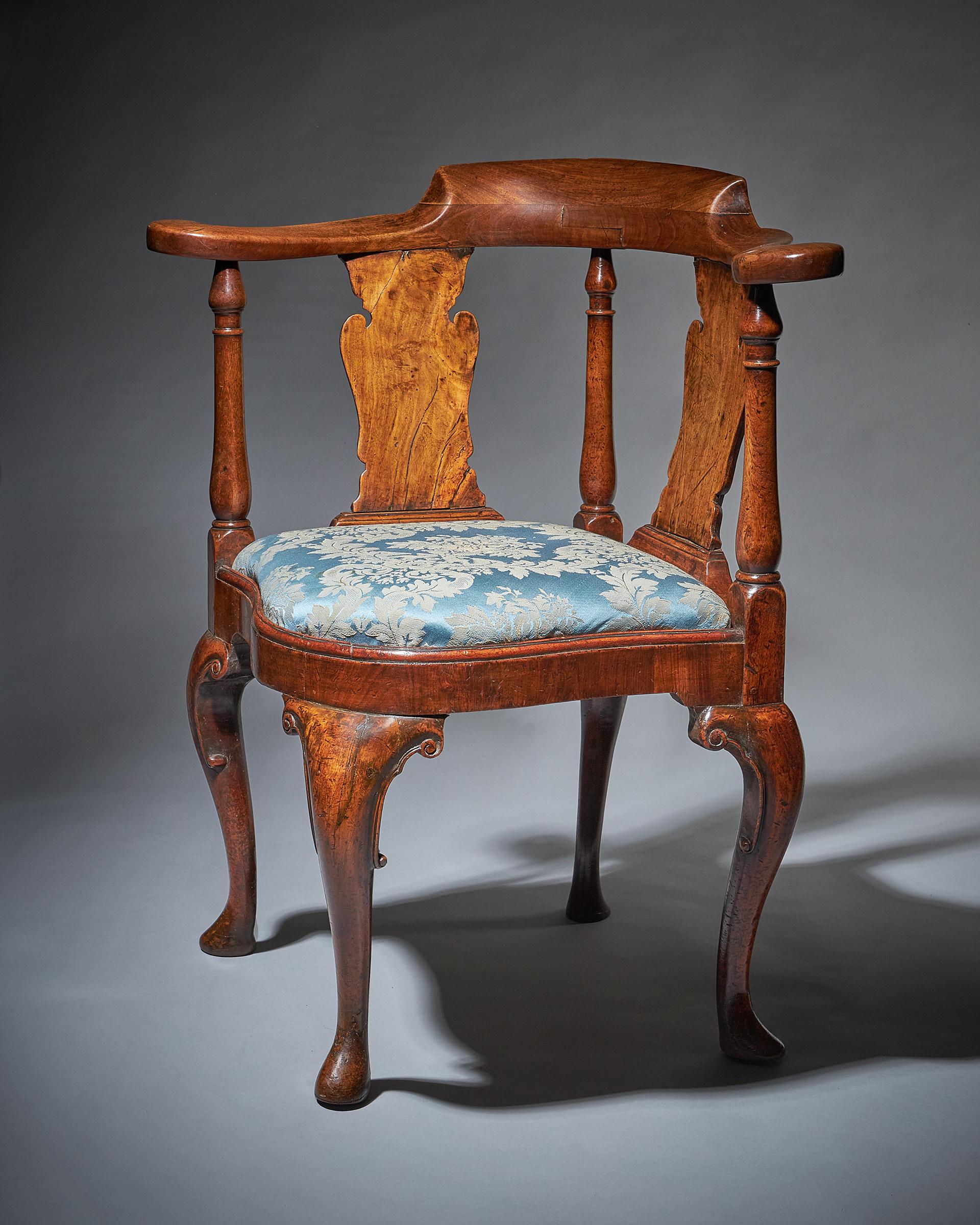 Queen Anne period walnut corner chair, 1702-1714.

It is solid walnut, raised on four boldly carved cabriole legs with C-scrolls and pad feet. The seat is known as bell-shaped. The solid walnut carved horseshoe crest rail is raised by three