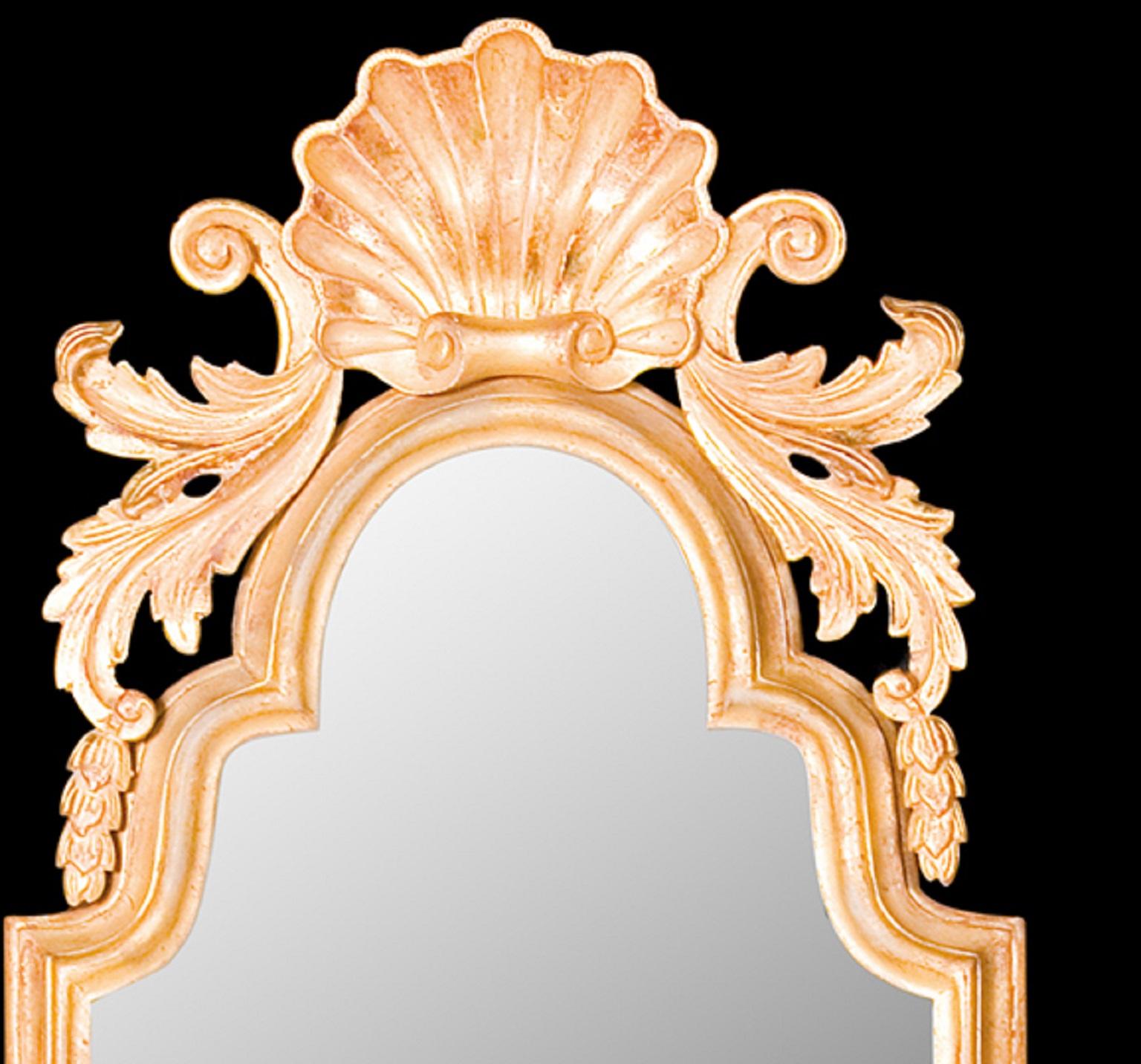 Questo bicchiere in legno dorato rappresenta una transizione di design tra il regno di Queen Anne e il periodo georgiano. La cornice semplice, a doppio arco e modanata, è arricchita da uno stemma intagliato a conchiglia affiancato da foglie d'acanto