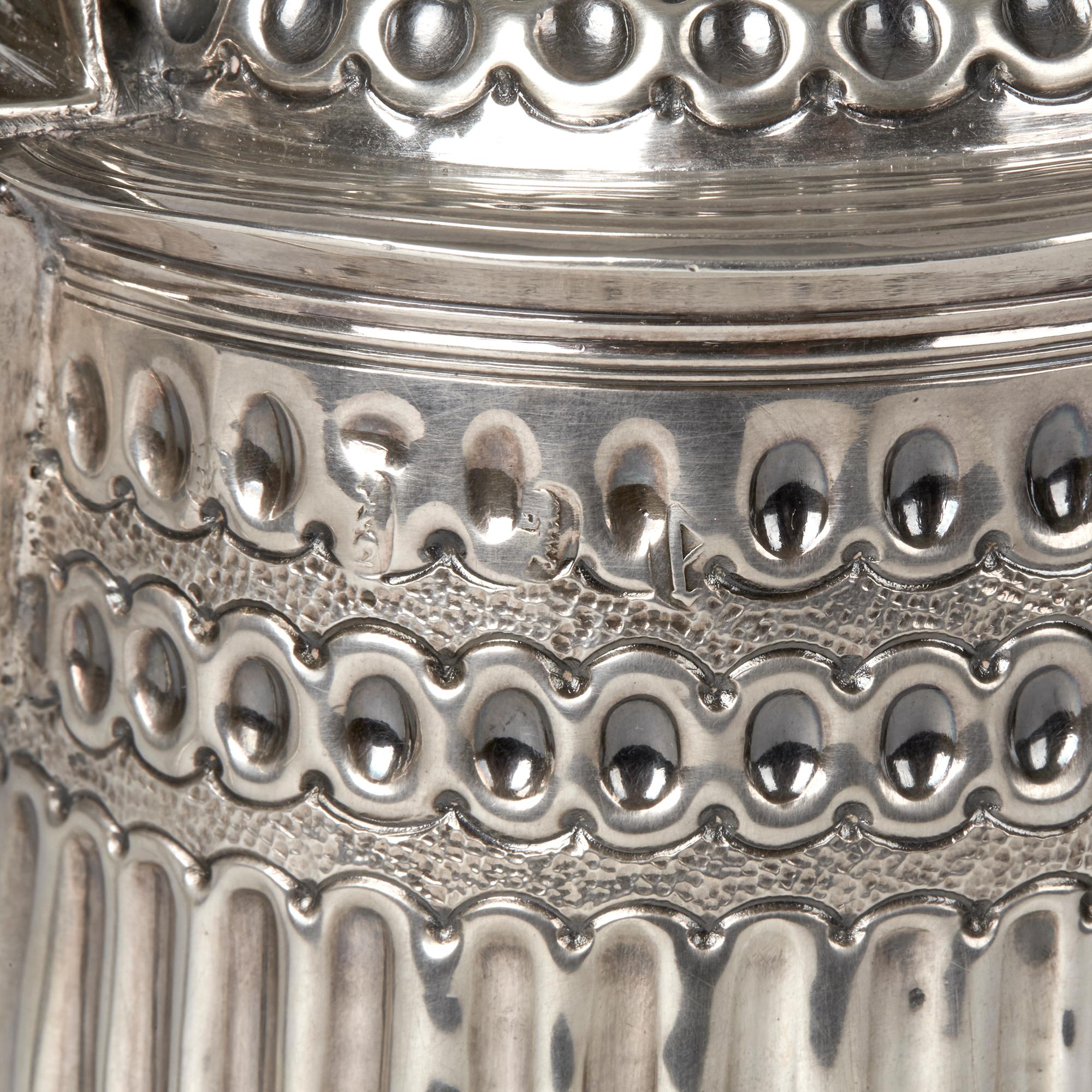 An exceptional antique Queen Anne silver lidded tankard with London silver assay marks for 1706. The tankard is lavishly decorated with a front cartouche bearing the Scottish crest for the Blane clan. The tankard is of cylindrical form with a