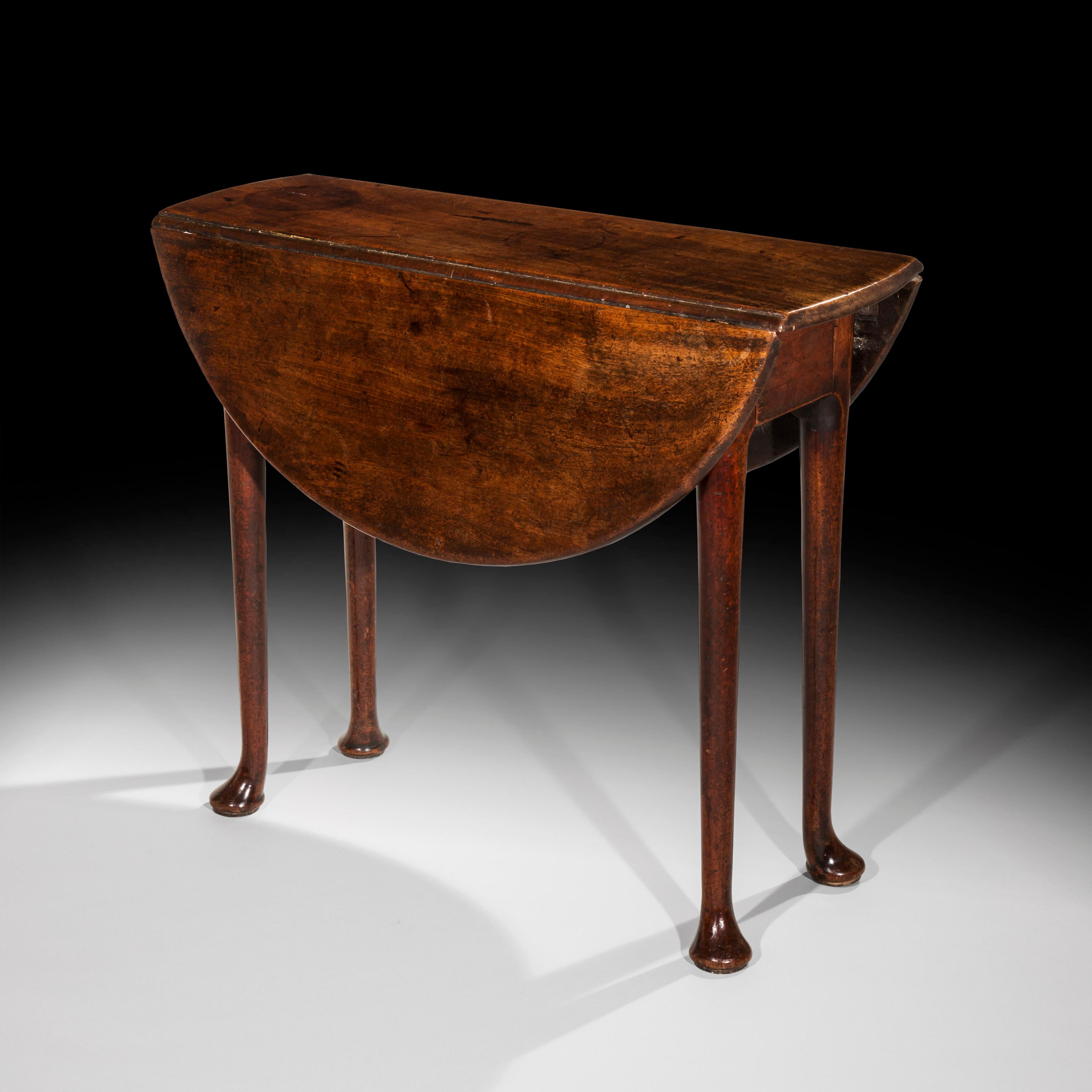 Just 11 inches deep with flaps down - very rare small table.

A minimalist early 18th century English provincial George II period oval drop-leaf table of rare shallow proportions, in red walnut, of wonderful original color and patination,

circa