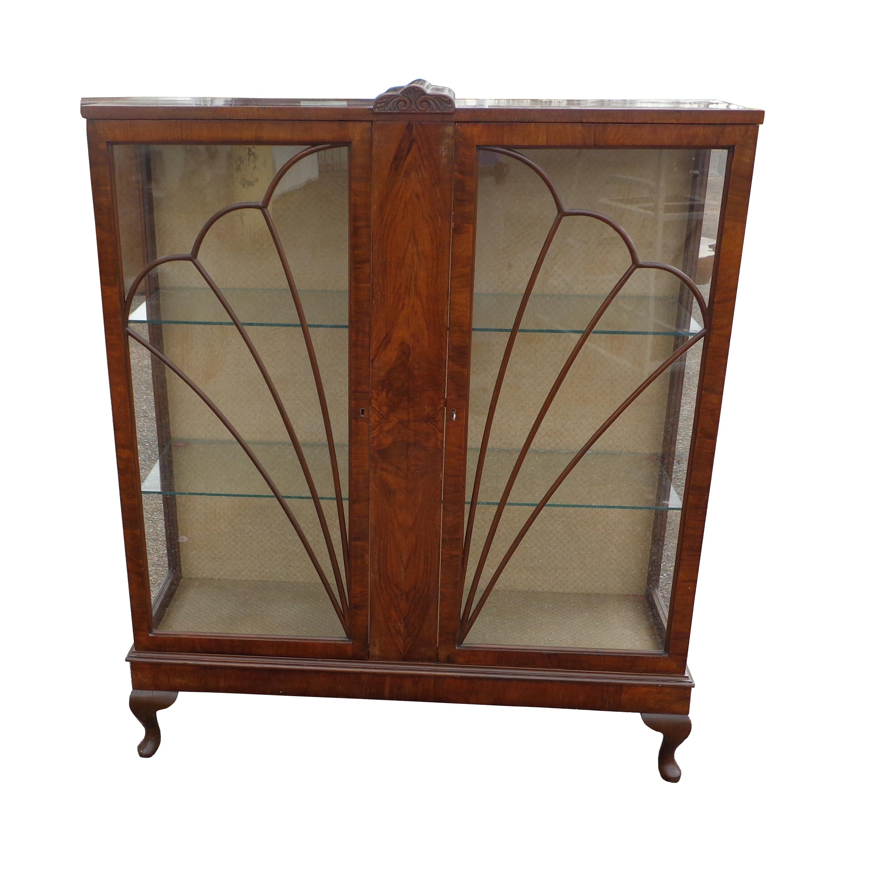 Queen Anne Art Deco glass display bookcase 

Art Deco curio bookcase from England circa 1920's. 

Burl wood with two glass doors inlaid with a beautiful leaded glass pattern. Two glass shelves and the original lock and working key included.