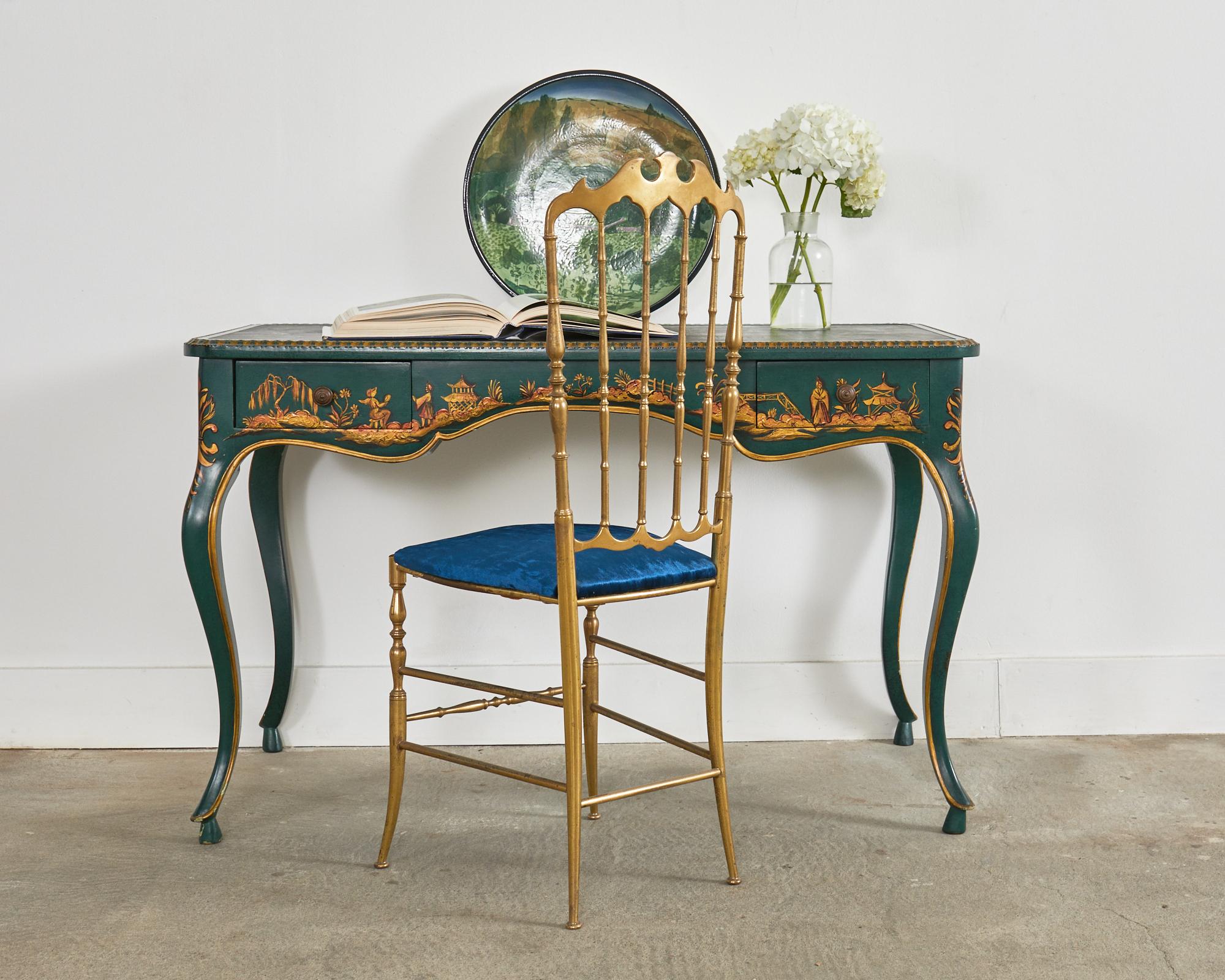 Gorgeous writing table desk or bureau plat made in the lovely Queen Anne style featuring an emerald green lacquered finish. Decorated in the chinoiserie revival taste with painted Asian reserves on the frieze. The desk is finished on all sides with