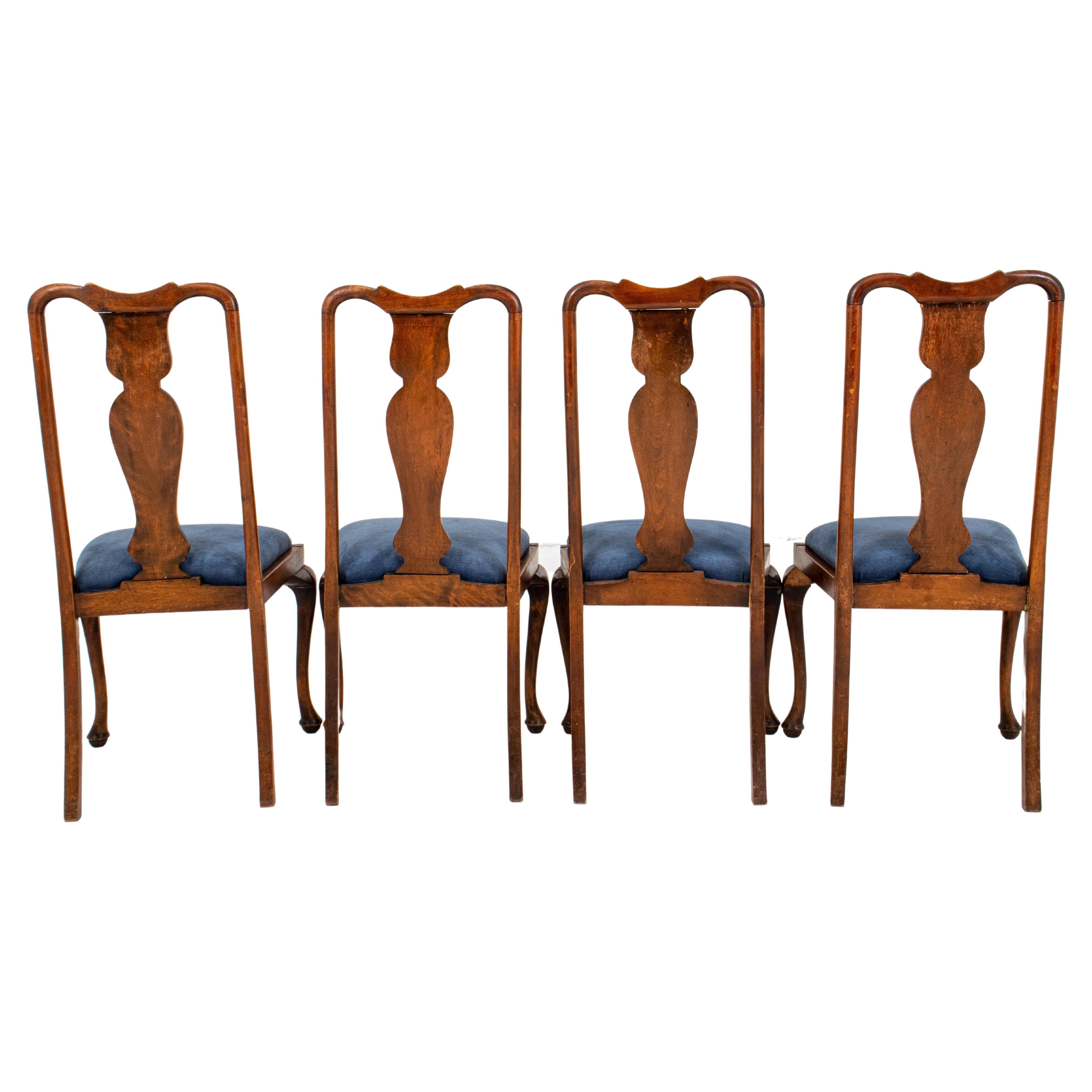 Set of four Queen Anne style wooden dining or side chairs with shaped crestrail, vase splats, and blue velvet-upholstered seats. 
Measures: 41.5