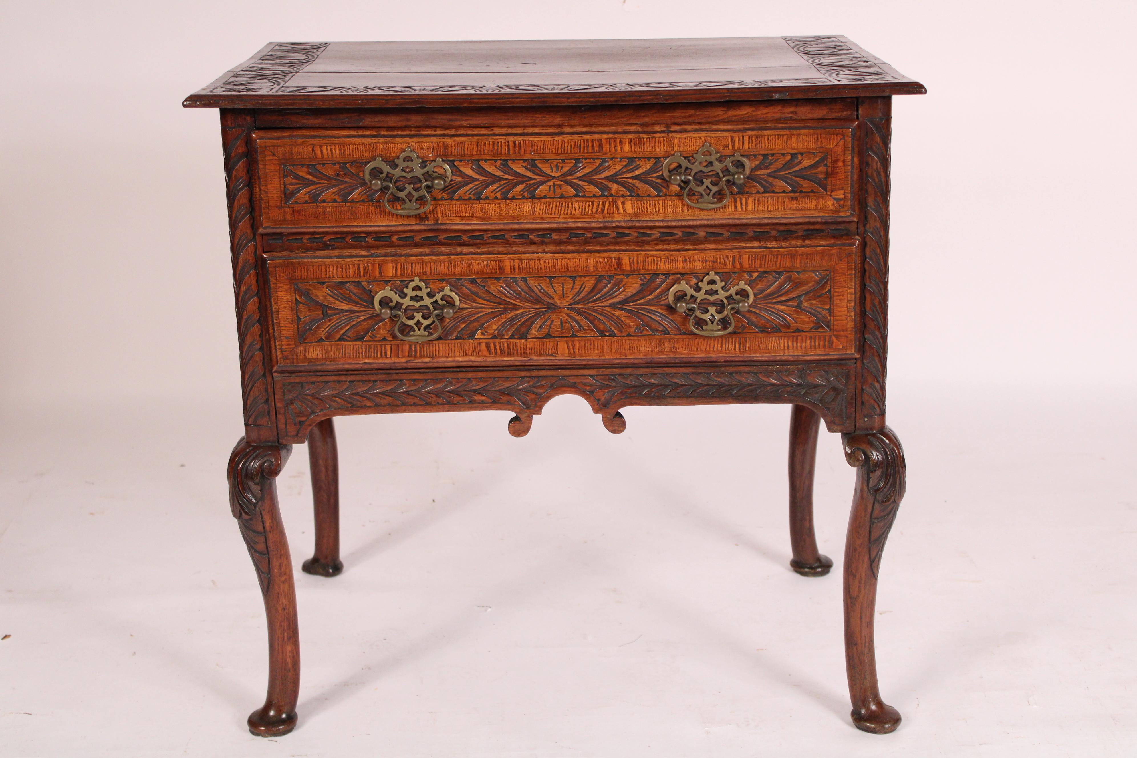 Bajera inglesa de roble estilo Queen Anne, siglo XIX. Con una encimera rectangular con el frente y los lados tallados, dos cajones de friso tallados y reticulados, que descansan sobre patas cabriolé acabadas en pies almohadillados. Bonito color.