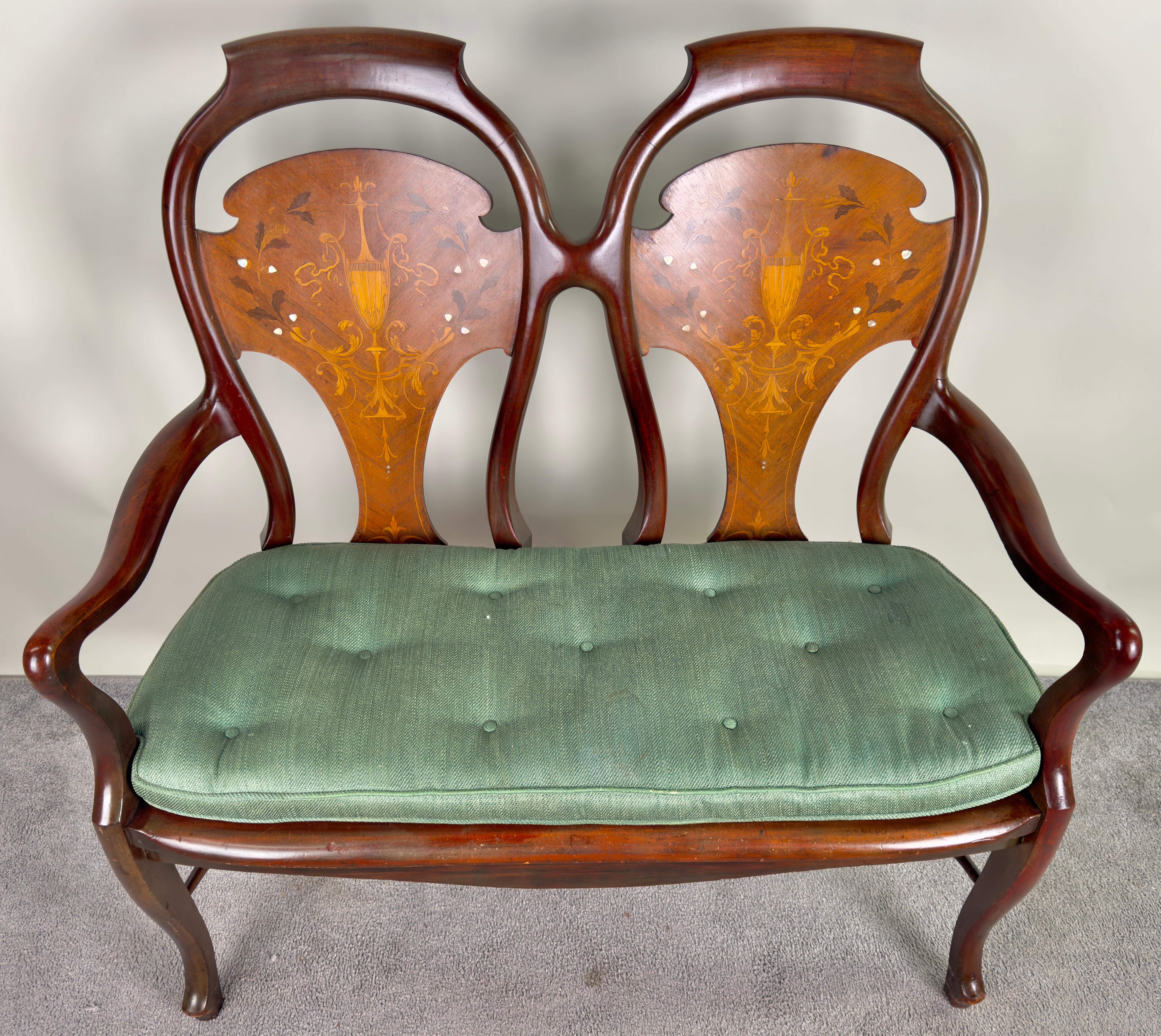 A  Queen Anne style two-seat settee, a masterpiece of refined craftsmanship. The seat back boasts rounded shoulders that exude sophistication. The inner panels show intricate marquetry inlay design. The meticulously carved arms and the Cabriole legs