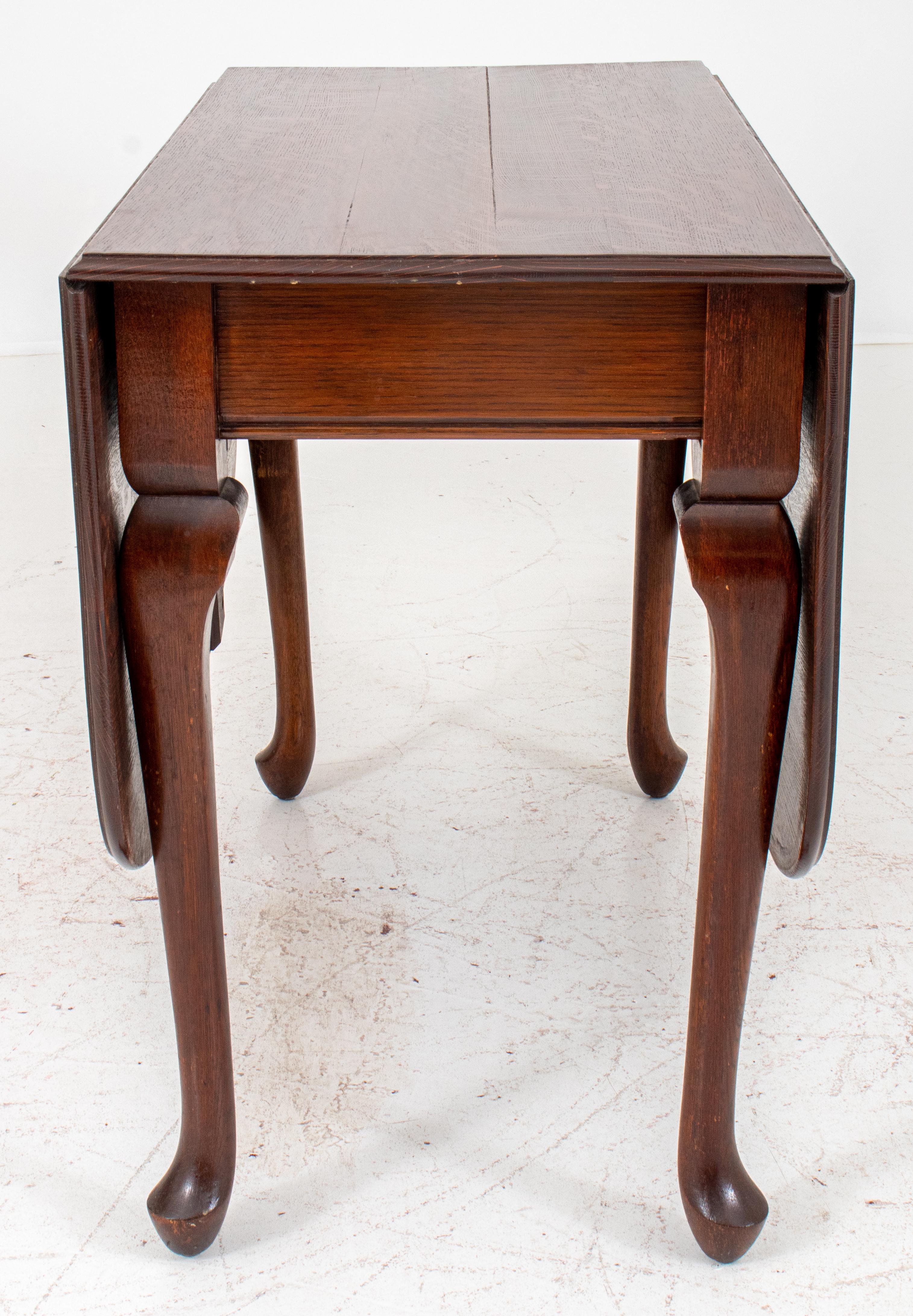 Queen Anne style quarter-sawn oak drop-leaf table, ca. 1890, rectangular, on cabriole legs terminating in pad feet. Measures: Closed: 30