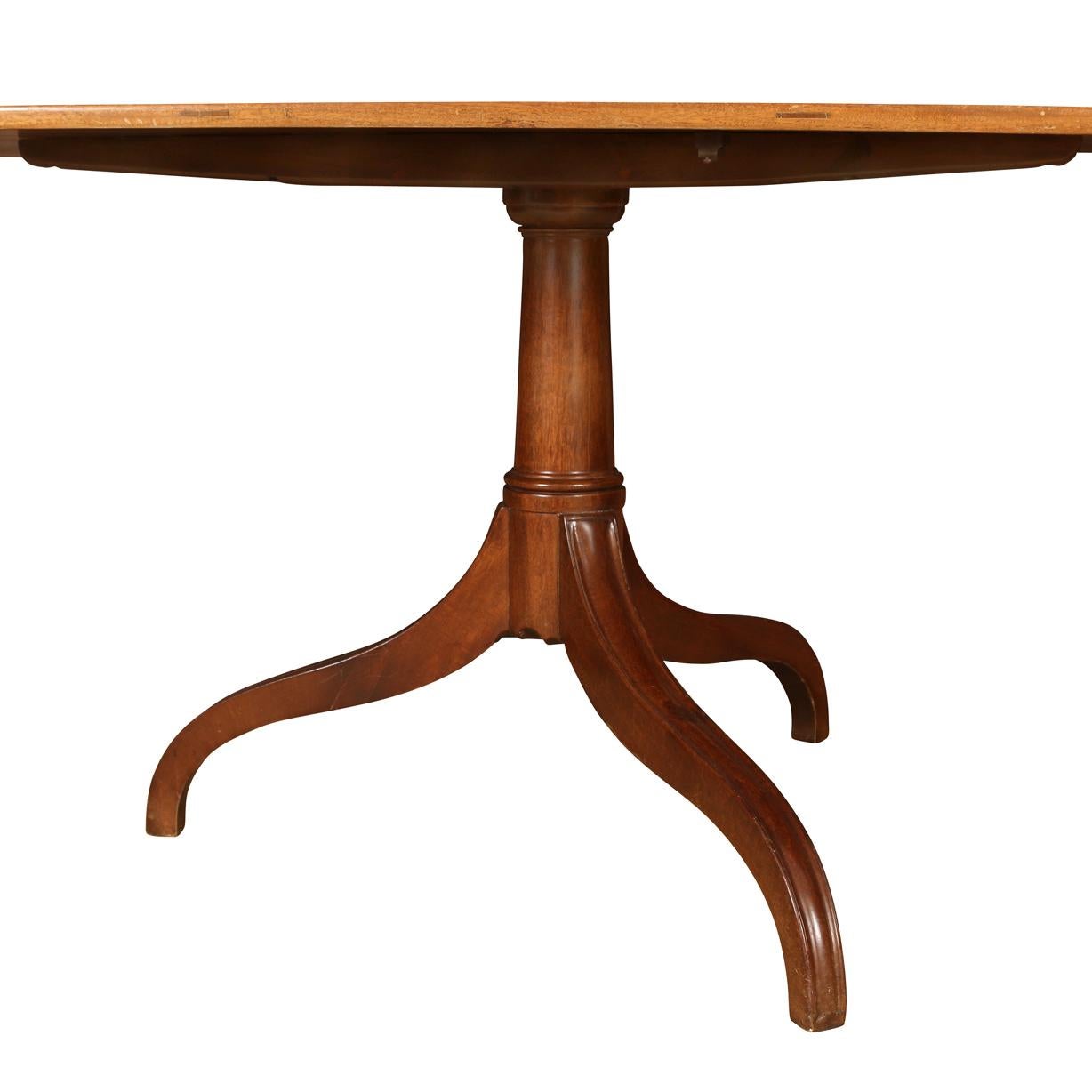 Queen Anne style pedestal dining table with three curved legs and rectangular top with rounded corners.