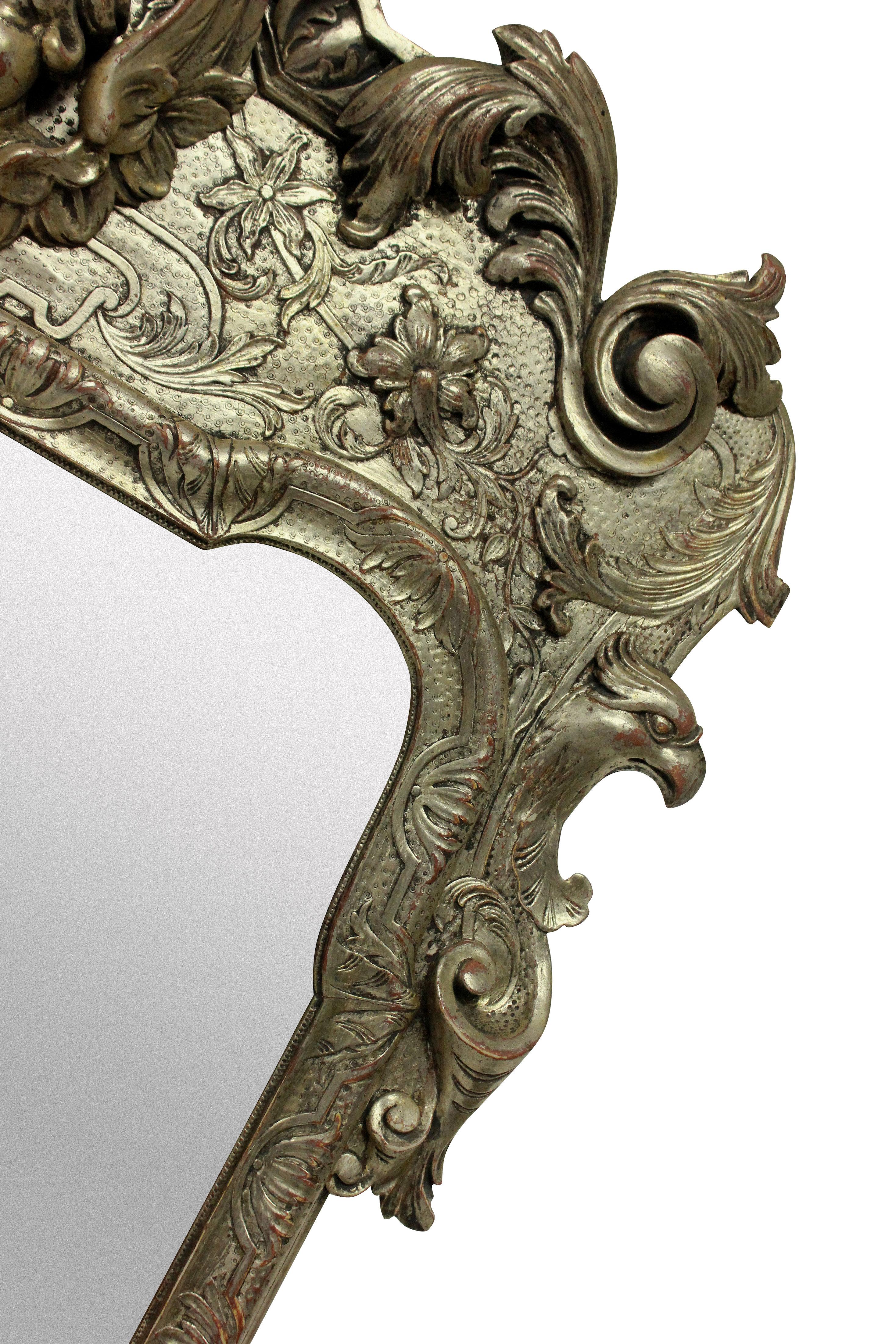 An English Queen Anne style carved and silver leaf mirror with a beveled plate.