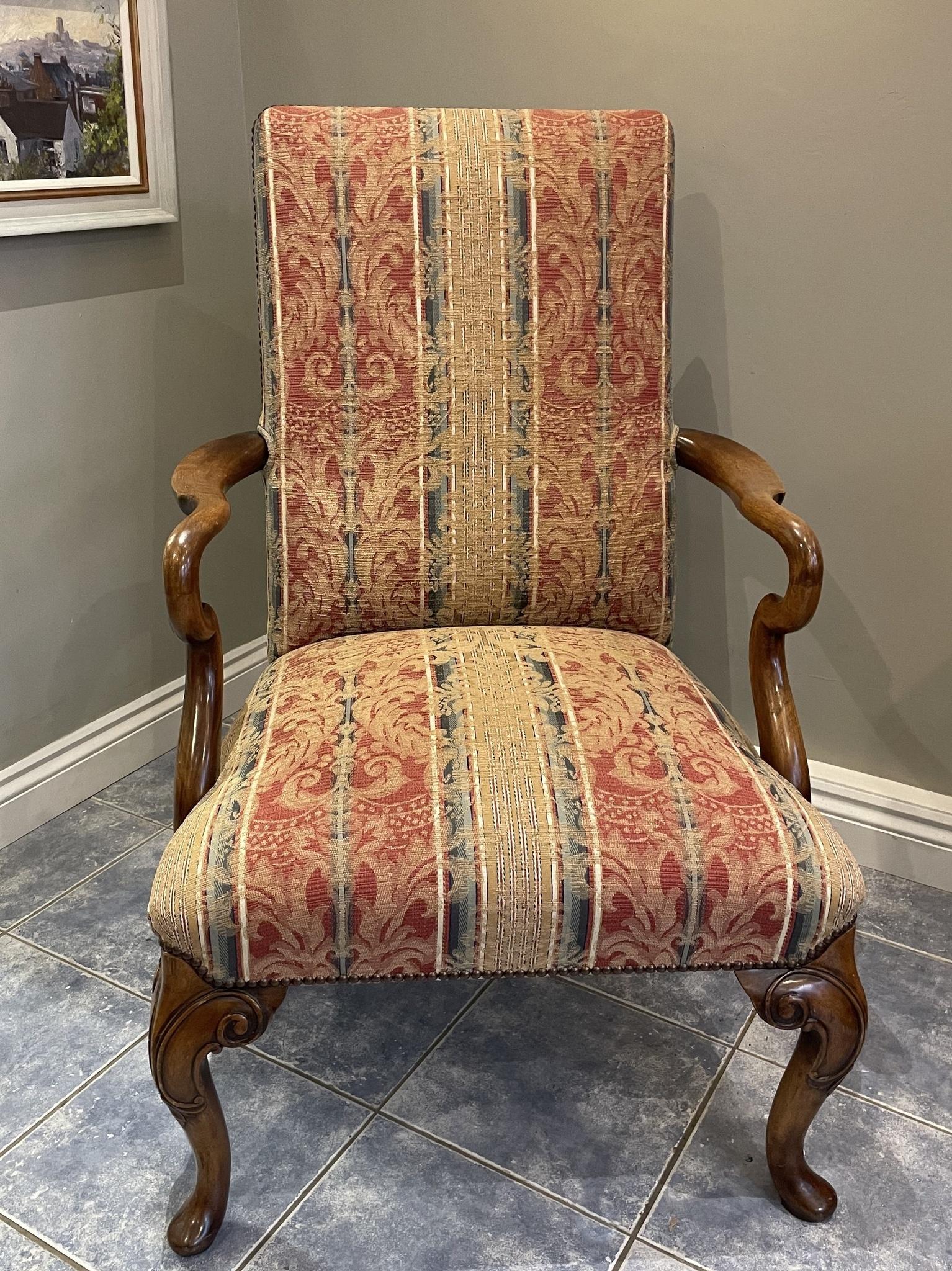Fauteuil ouvert de style Queen Anne en noyer, avec des bras en forme de crochet de berger aux formes élégantes, reposant sur des pieds cabriole à l'avant et des pieds arrière gracieusement balayés, tous deux terminés par des pieds en forme de