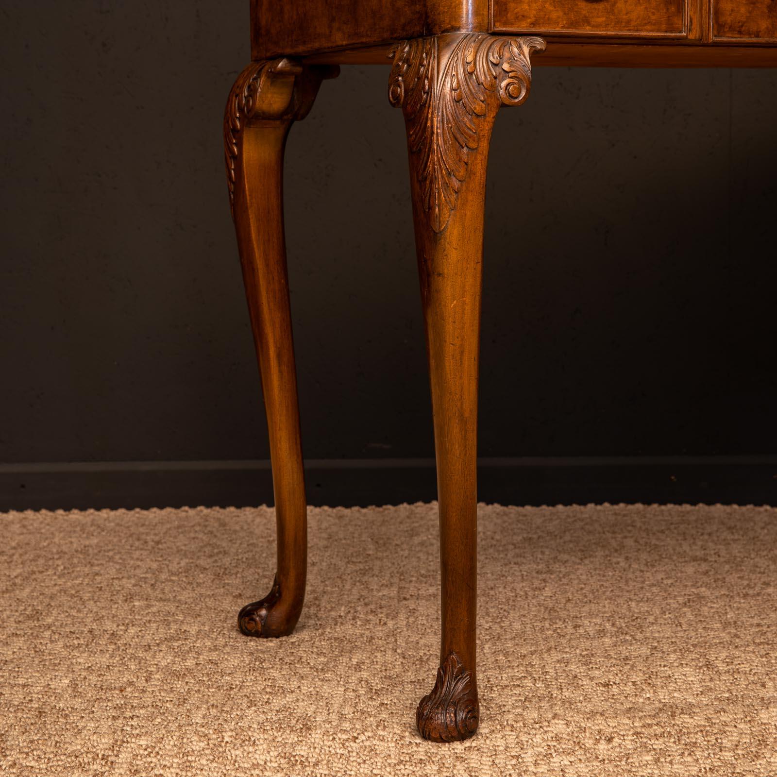 A super quality Queen Anne style side table with beautiful burr walnut veneers to the top and drawer fronts. Of inverted form and sat on well carved cabriole legs. The whole piece is in excellent condition still retaining it's original plate glass