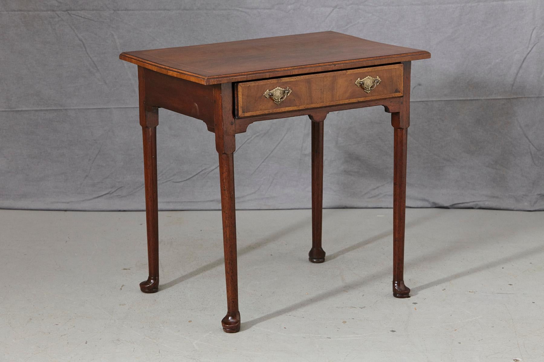 Beautiful crafted late 19th century Queen Anne style rectangular-shaped walnut side table with wood inlays around the drawer and the top, standing on straight legs and pad feet. Full drawer with original brass hardware.