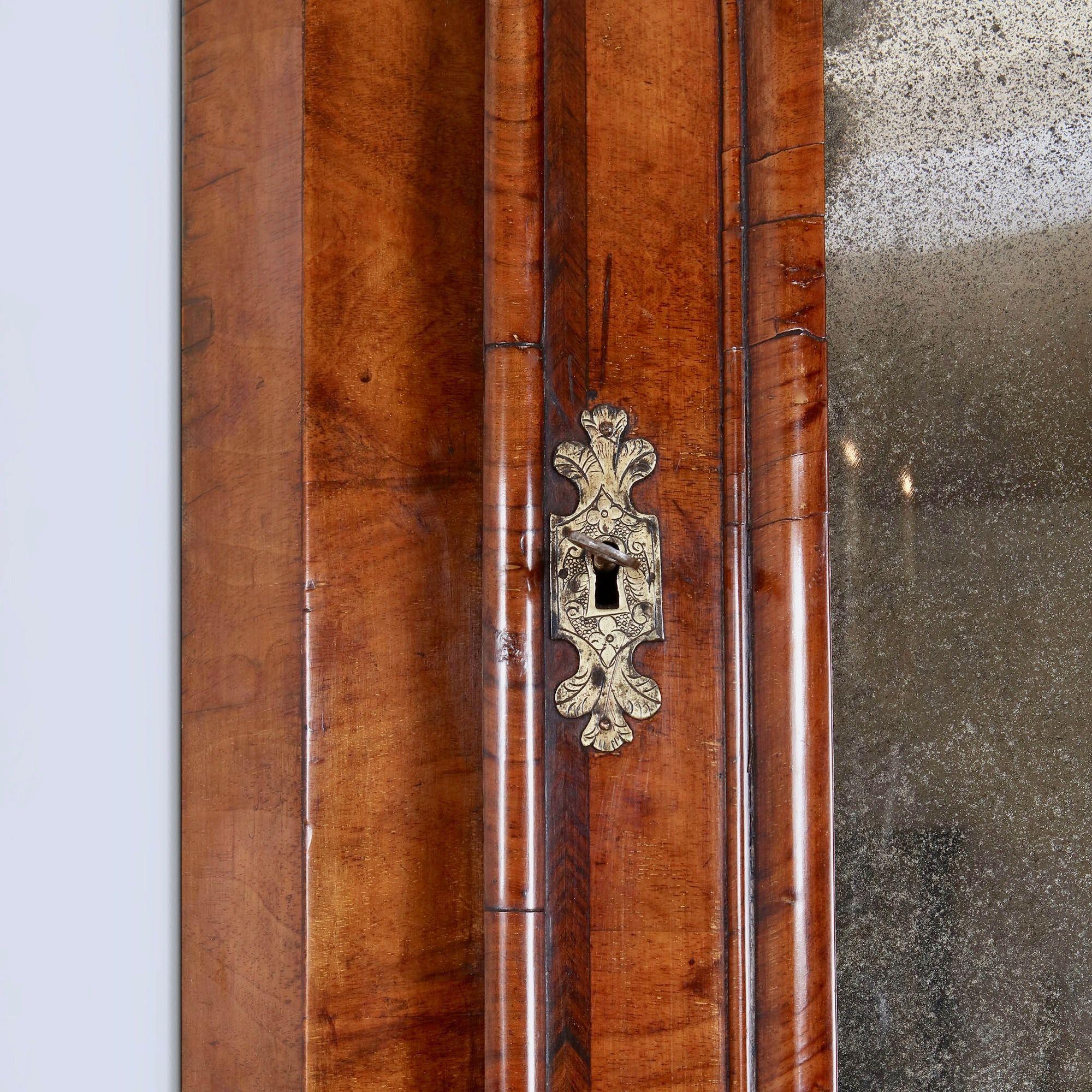 Ein wirklich bemerkenswerter Fund im Originalzustand. 
An der Tür wird eine geformte, weich abgeschrägte Spiegelplatte von einer quer verlaufenden Leiste im typischen Queen-Anne-Design umrahmt, die außerdem mit einem Querband und einer Federleiste