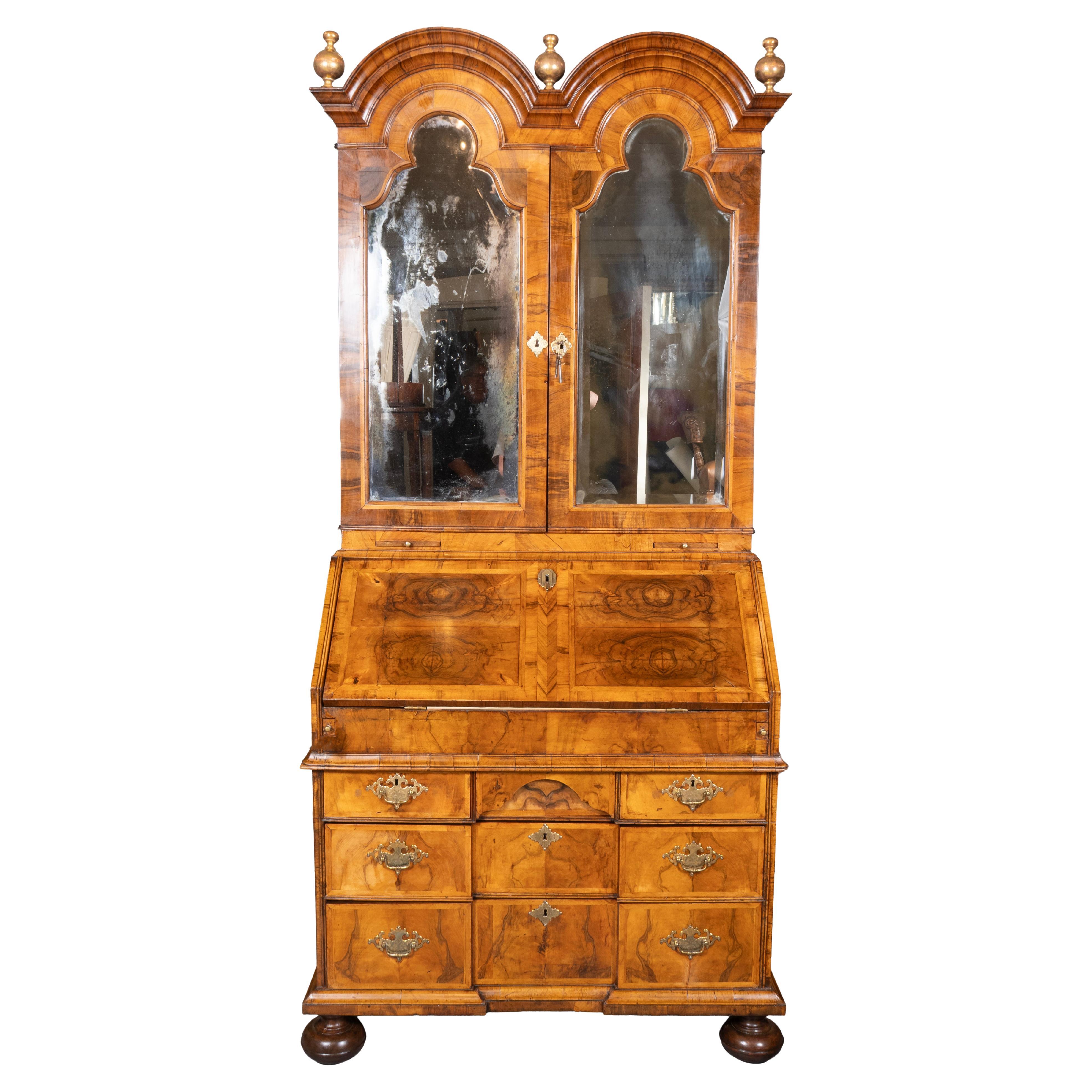 La partie supérieure est surmontée d'une double coupole et de trois fleurons en bois doré, le tout surmonté d'une paire de portes à miroir. Les portes renferment un intérieur aménagé avec des compartiments, des tiroirs et des portes. La base avec