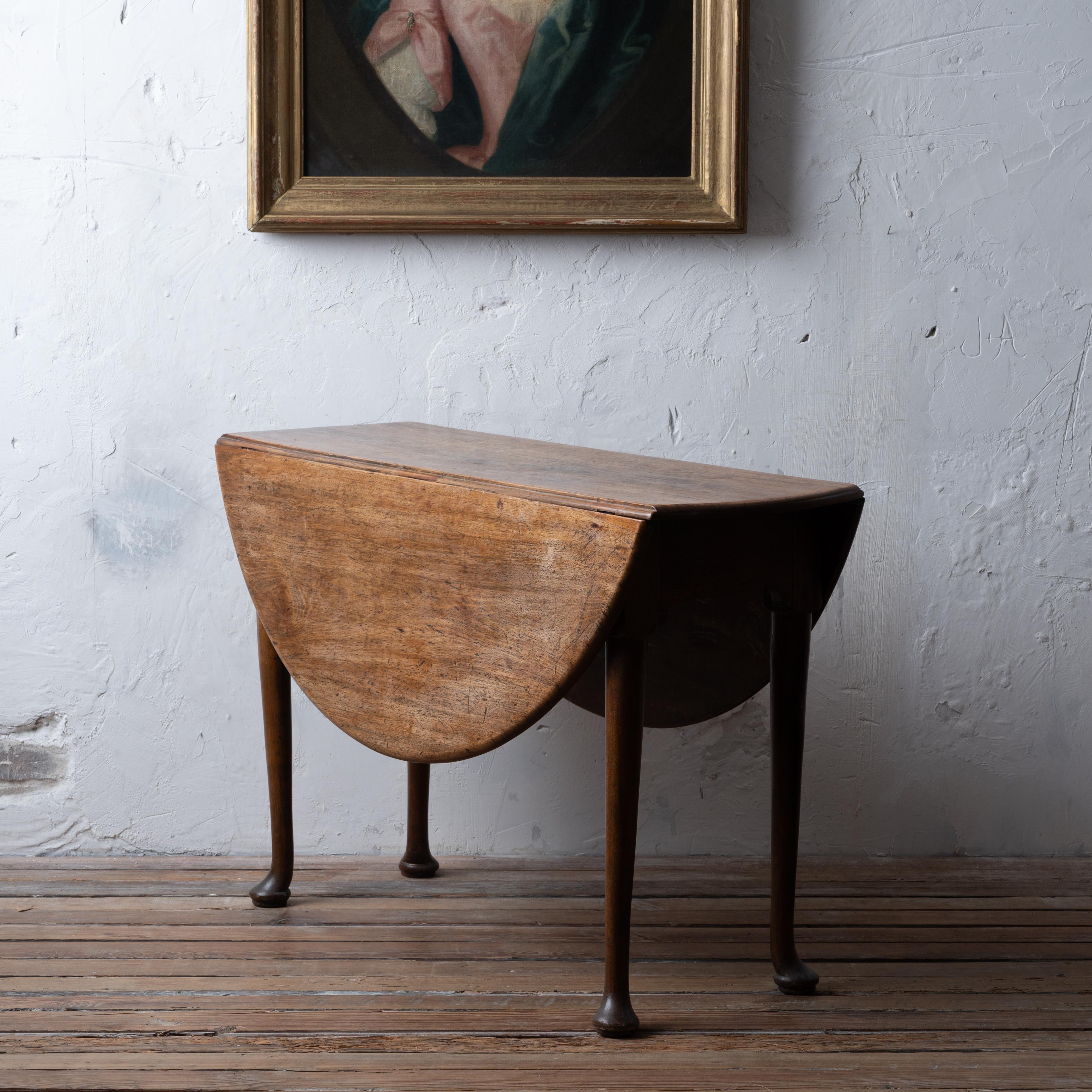 A Queen Anne walnut drop-leaf table, English, circa 1740.
Oak aprons and secondary.

42 ½ inches wide by 15 ½ inches deep by 28 inches tall;  45 inches extended


