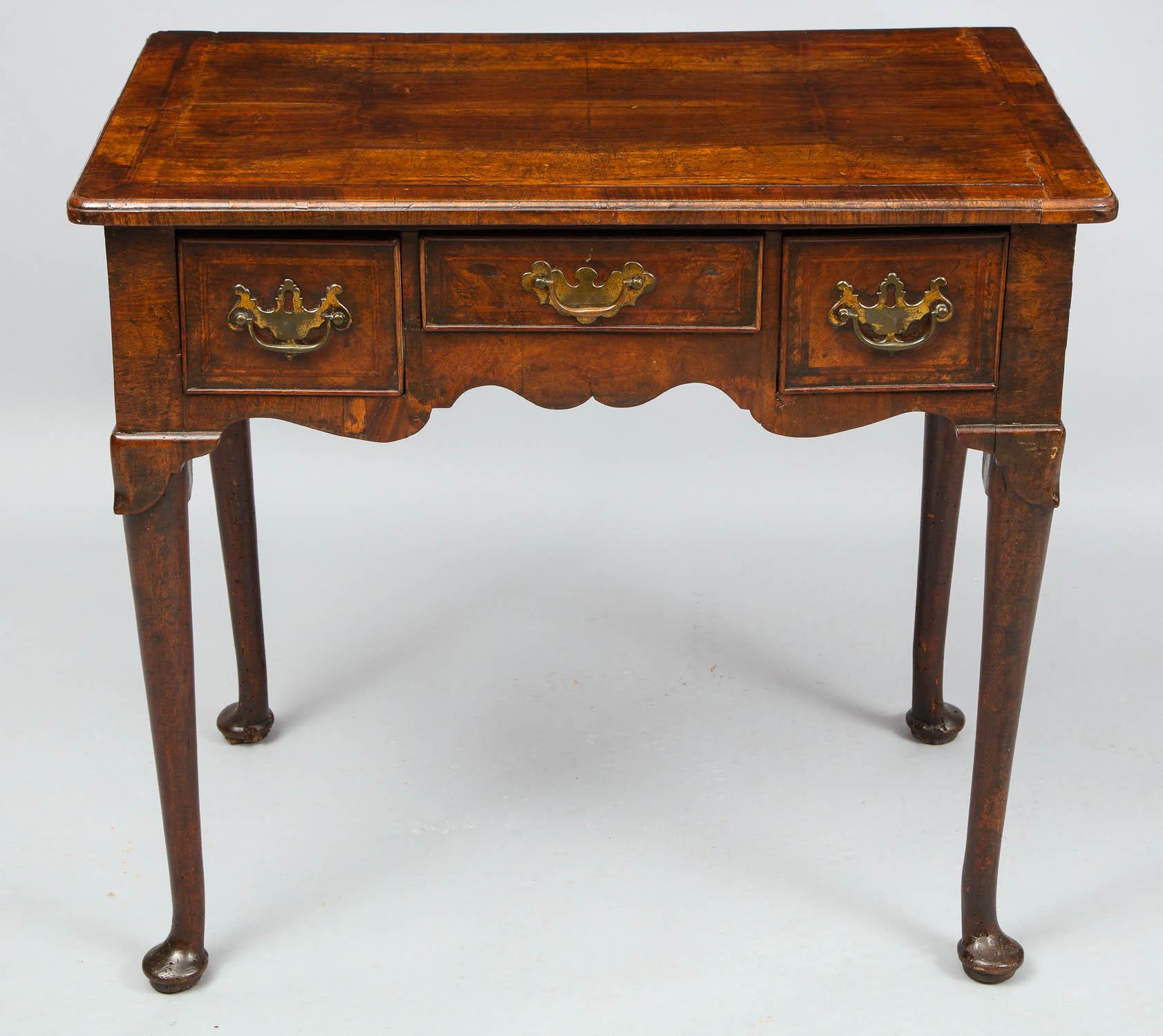 Fine early 18th century English walnut lowboy, the book-matched top with herringbone inlay and cross banding, with molded edge over two short and one longer drawer over scalloped apron, the legs with lappet knees and pad feet, the whole possessing