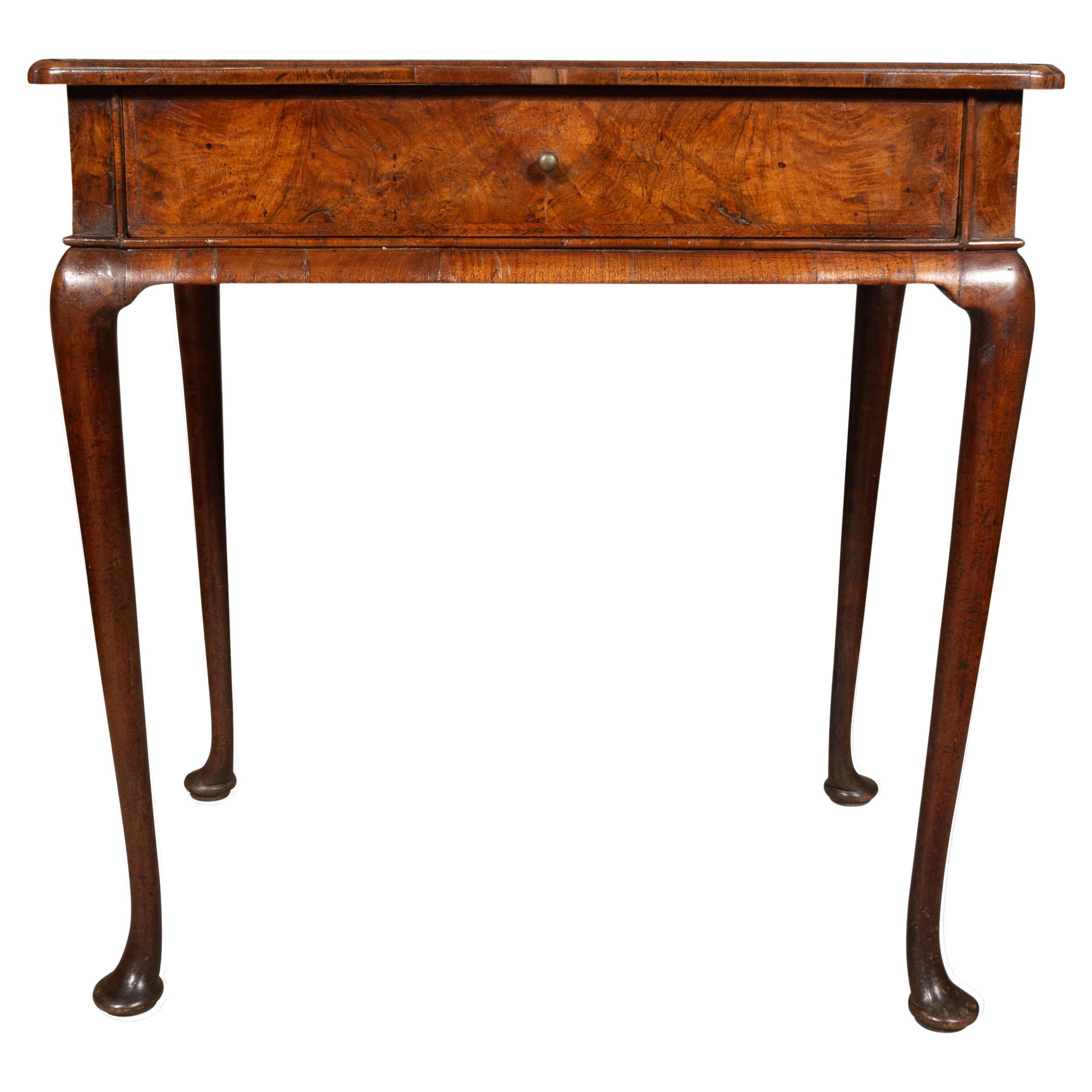 A fine little table with pinched molded corners. I great condition with wonderful   
figured veneers . The frieze with a single drawer with brass knob handle. With slight cabriole legs ending on pad feet.     