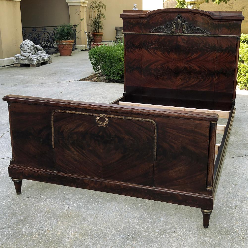 Antique French neoclassical mahogany Queen bed is a superlative study in architecture that dates back to ancient Greece and Rome! Using exotic imported mahogany to create a flame pattern on the head and footboard panels, the expert craftsmen who
